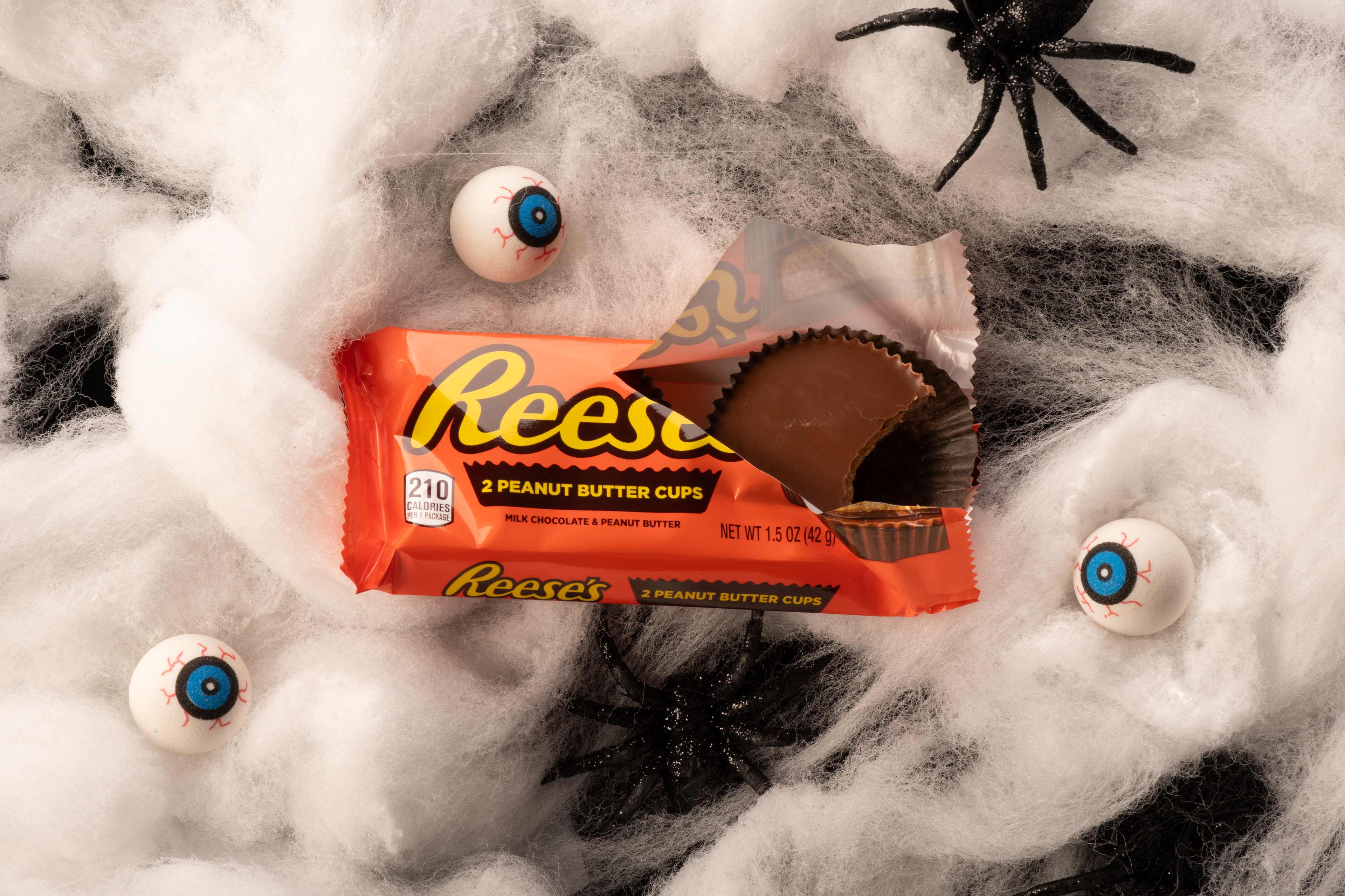 Reese's Cups shot on web stuffing with fake rubber eyes and spiders