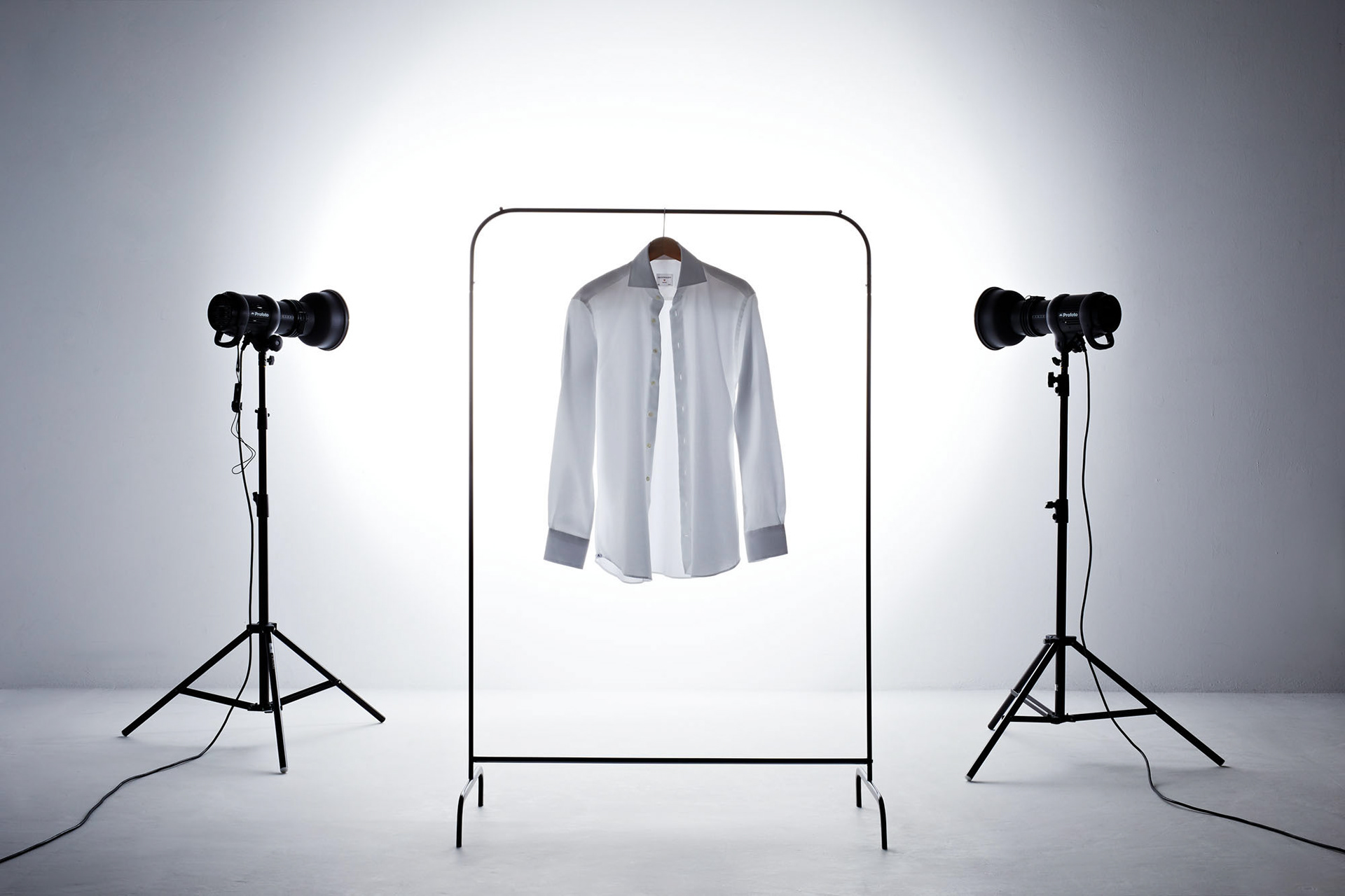 Still life photo in studio setting of a white shirt on a hanger with back light