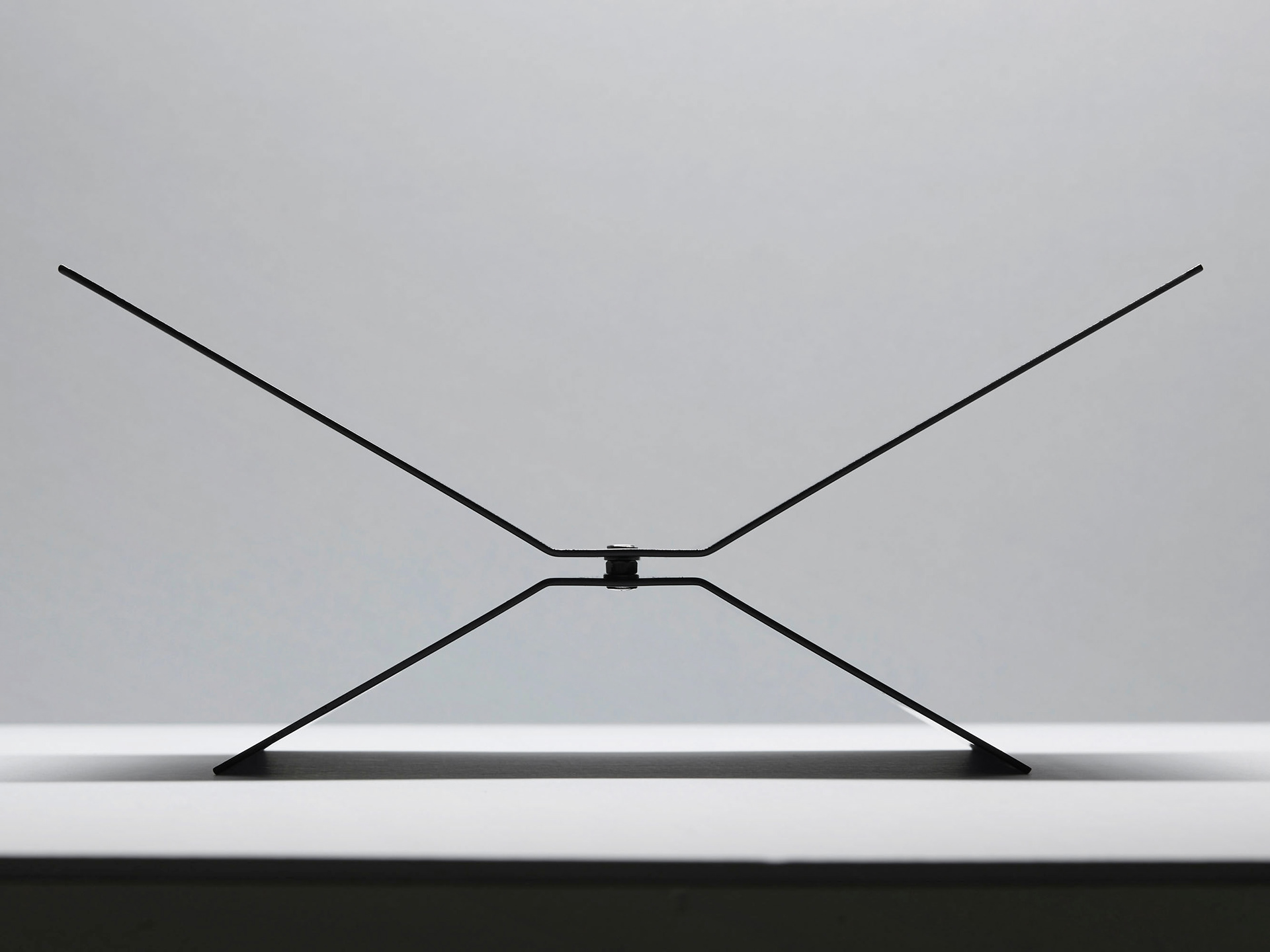 silhouet product image of a black bookstand highlighted with soft light on a neutral background showing the shape of the product