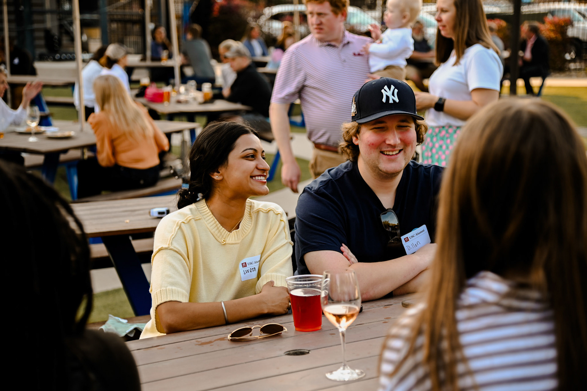 Alumni smiling at a picnic table