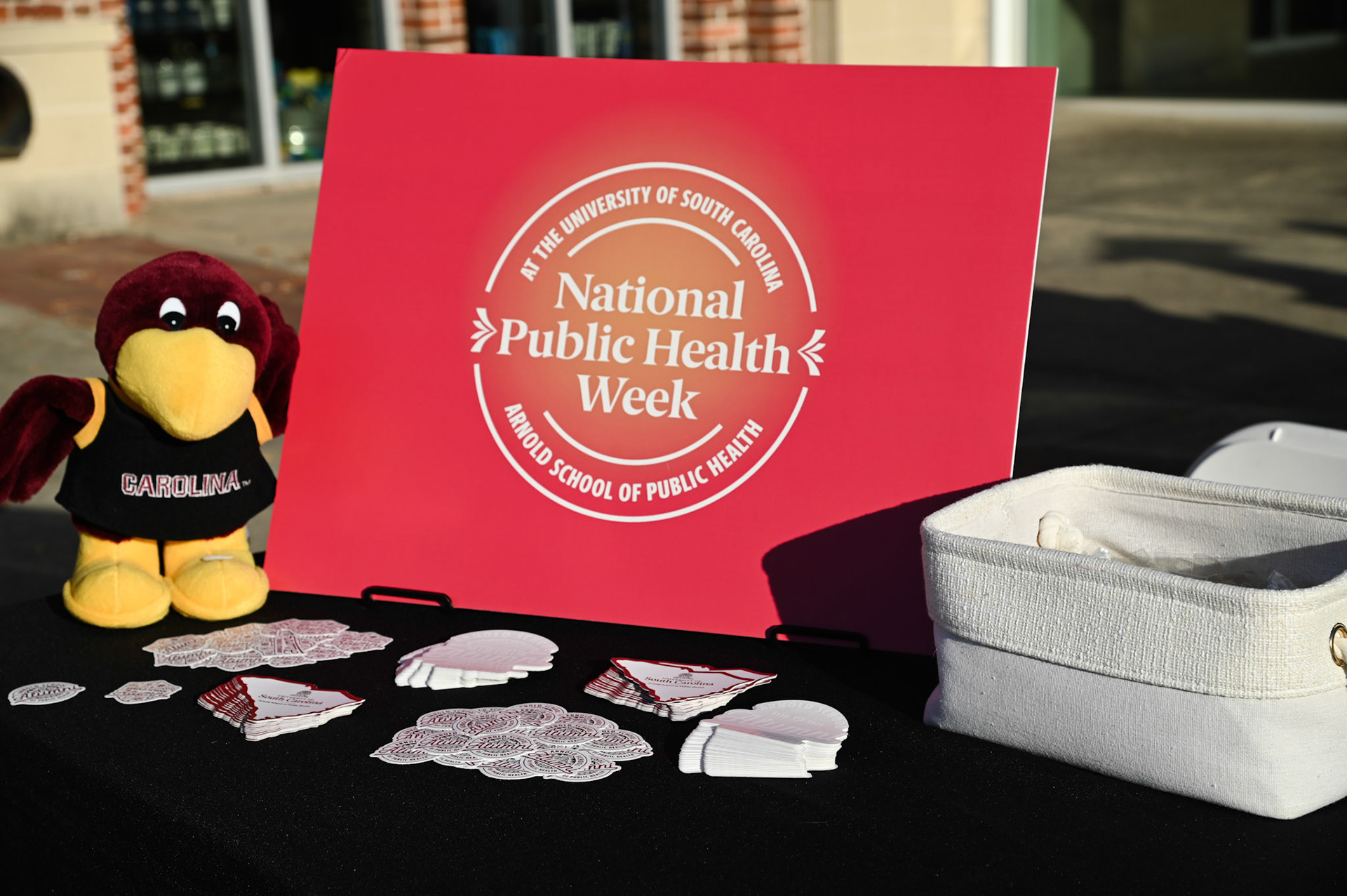 Sign on the welcome table for the event that says, "National Public Health Week at the University of South Carolina Arnold School of Public Health"