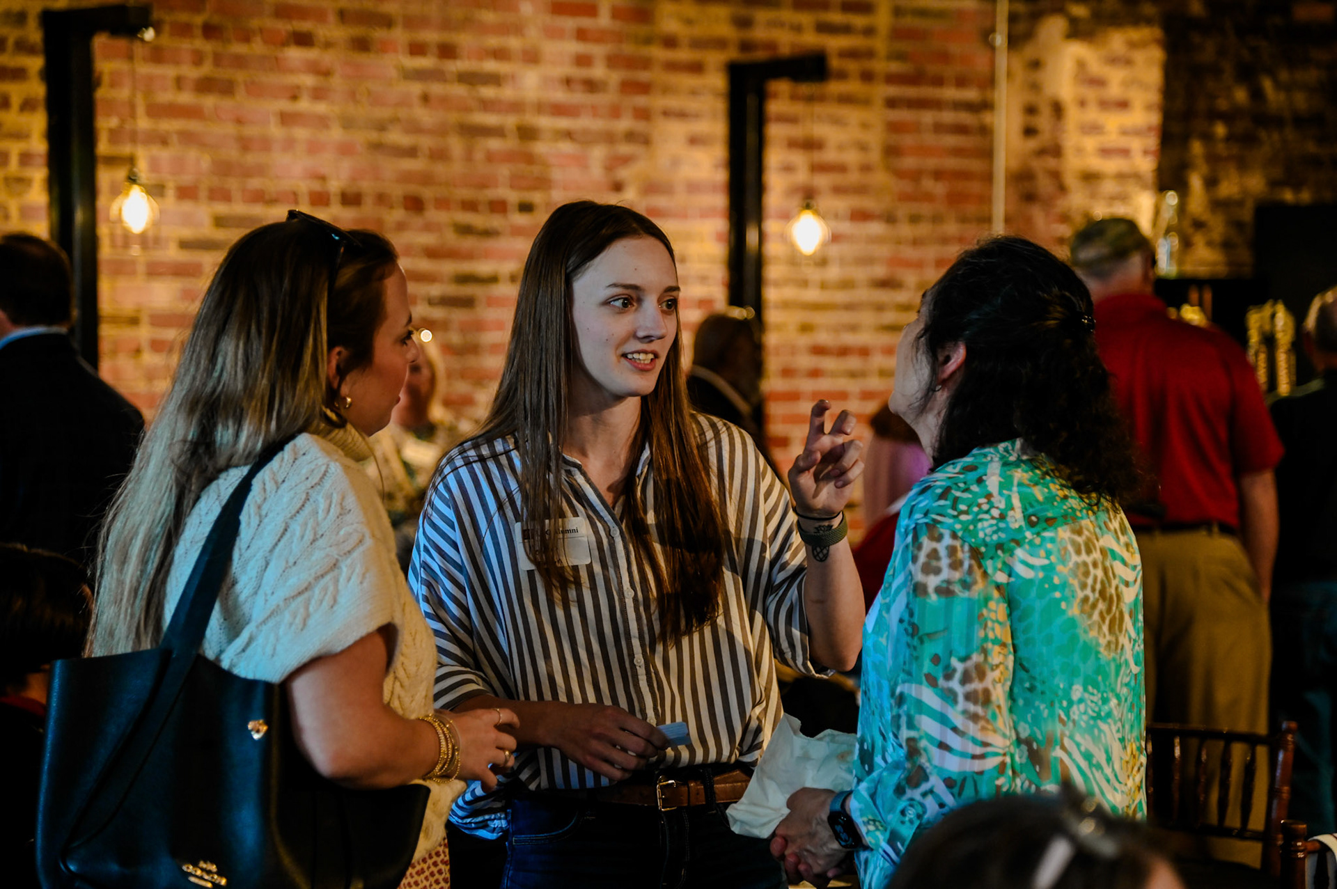 Two alumni women talking with Myriam Torres