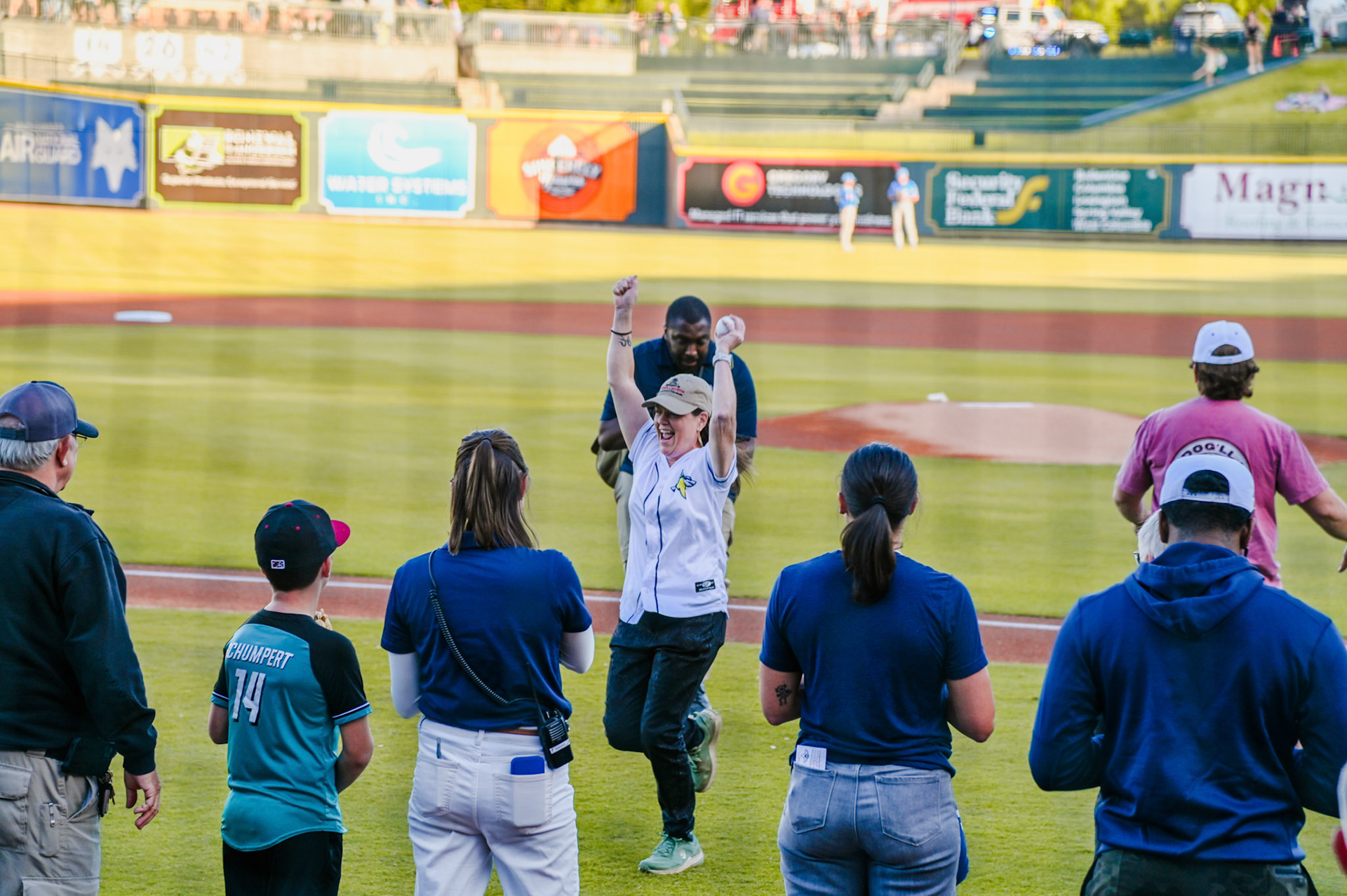 Dean Sabo-Attwood celebrating on the field after thowing the first pitch of the basesball game