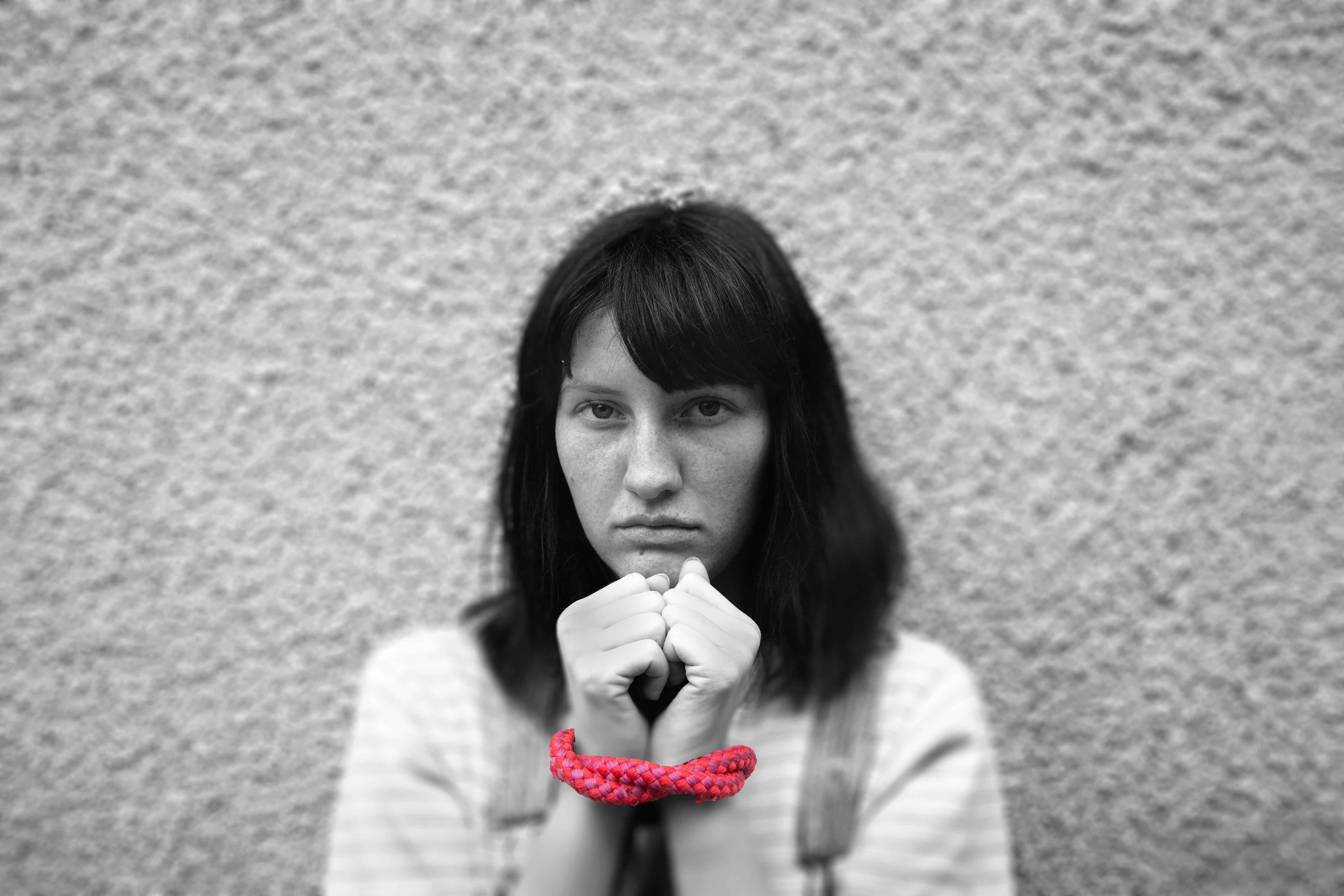 Woman has hands tied together.