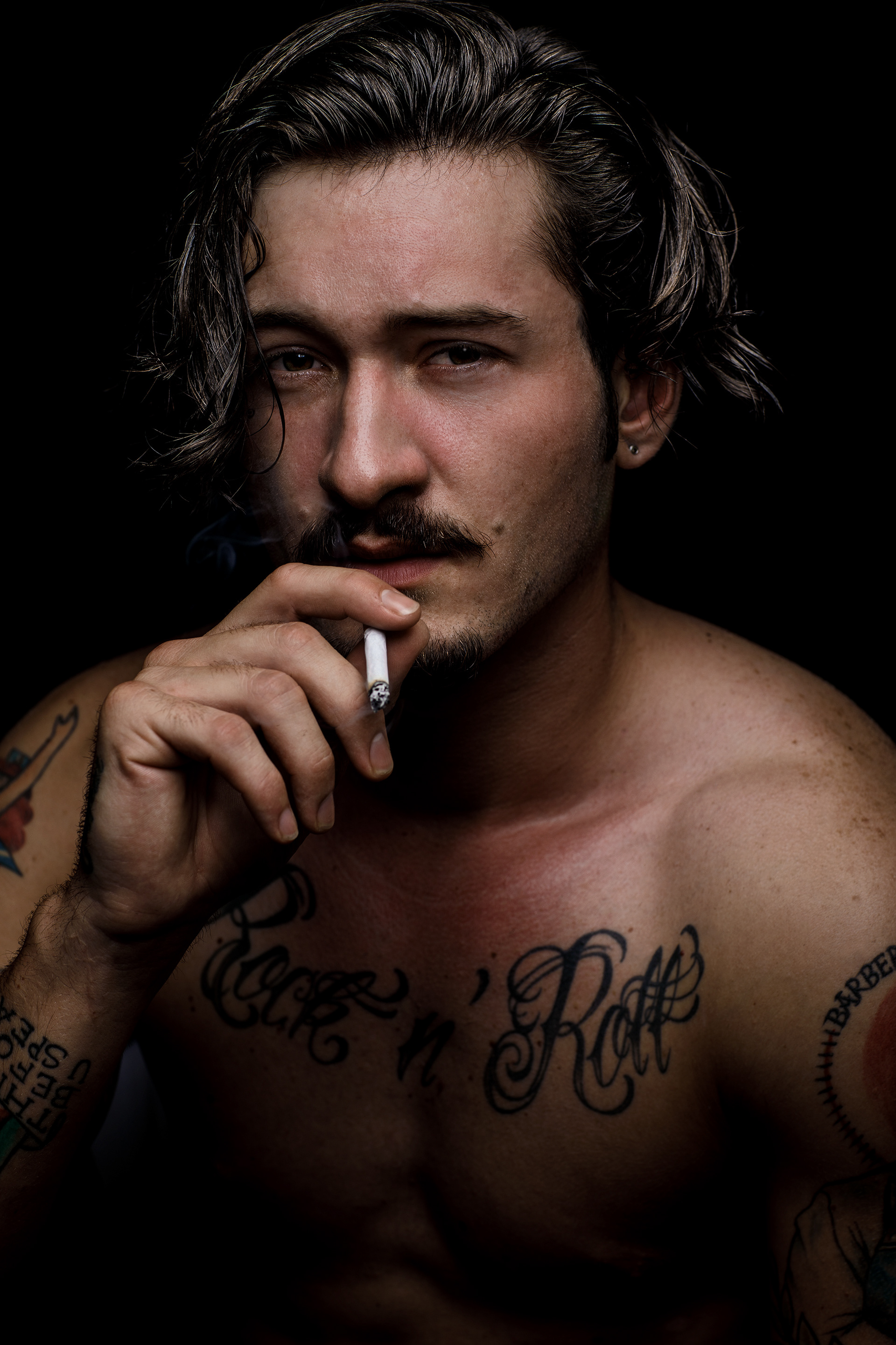 Charakterportrait junger Mann mit Tattoos 