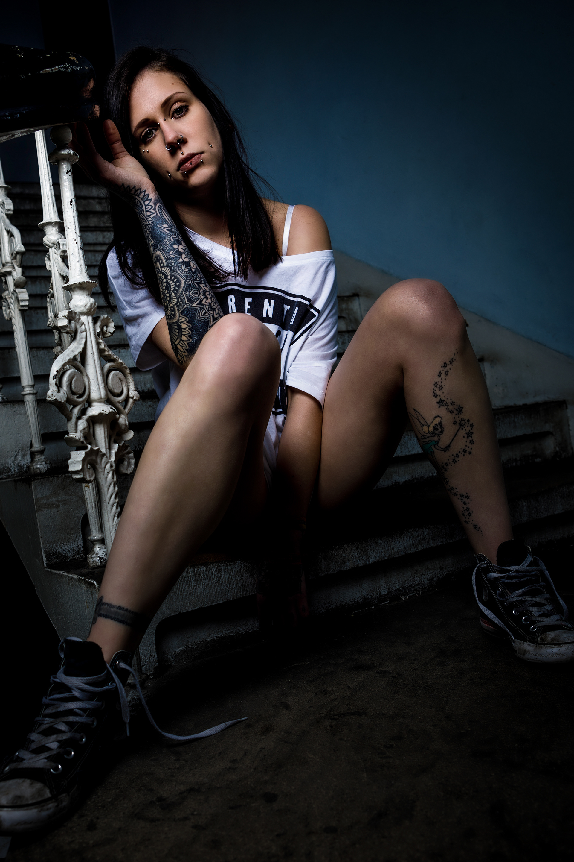 Portrait junge Frau mit Tattoo und Piercing in Treppenhaus