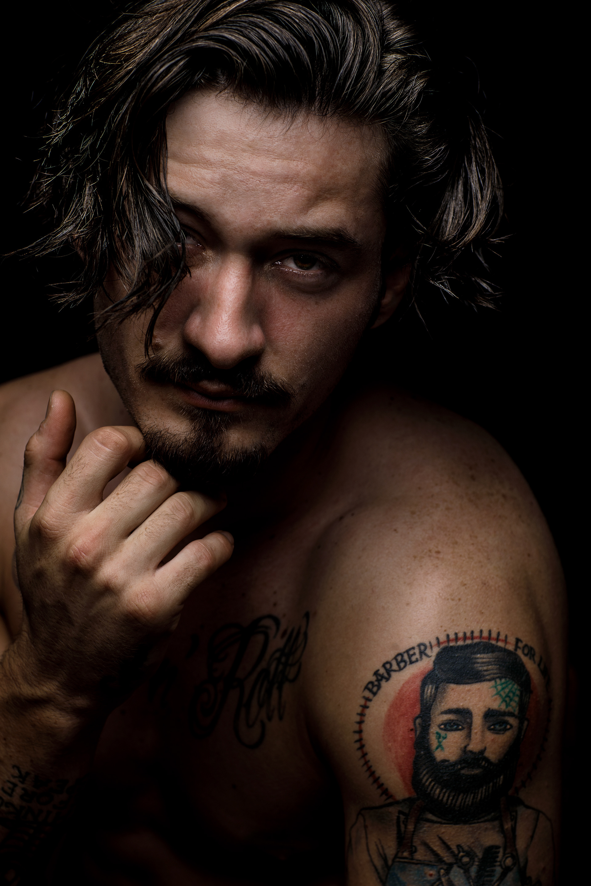 Charakterportrait junger Mann mit Barber Tattoos