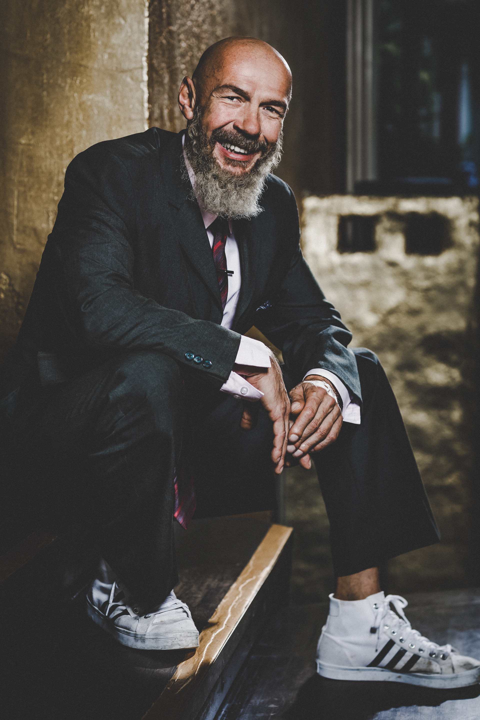 sitzender Mann lachend in coolem Outfit