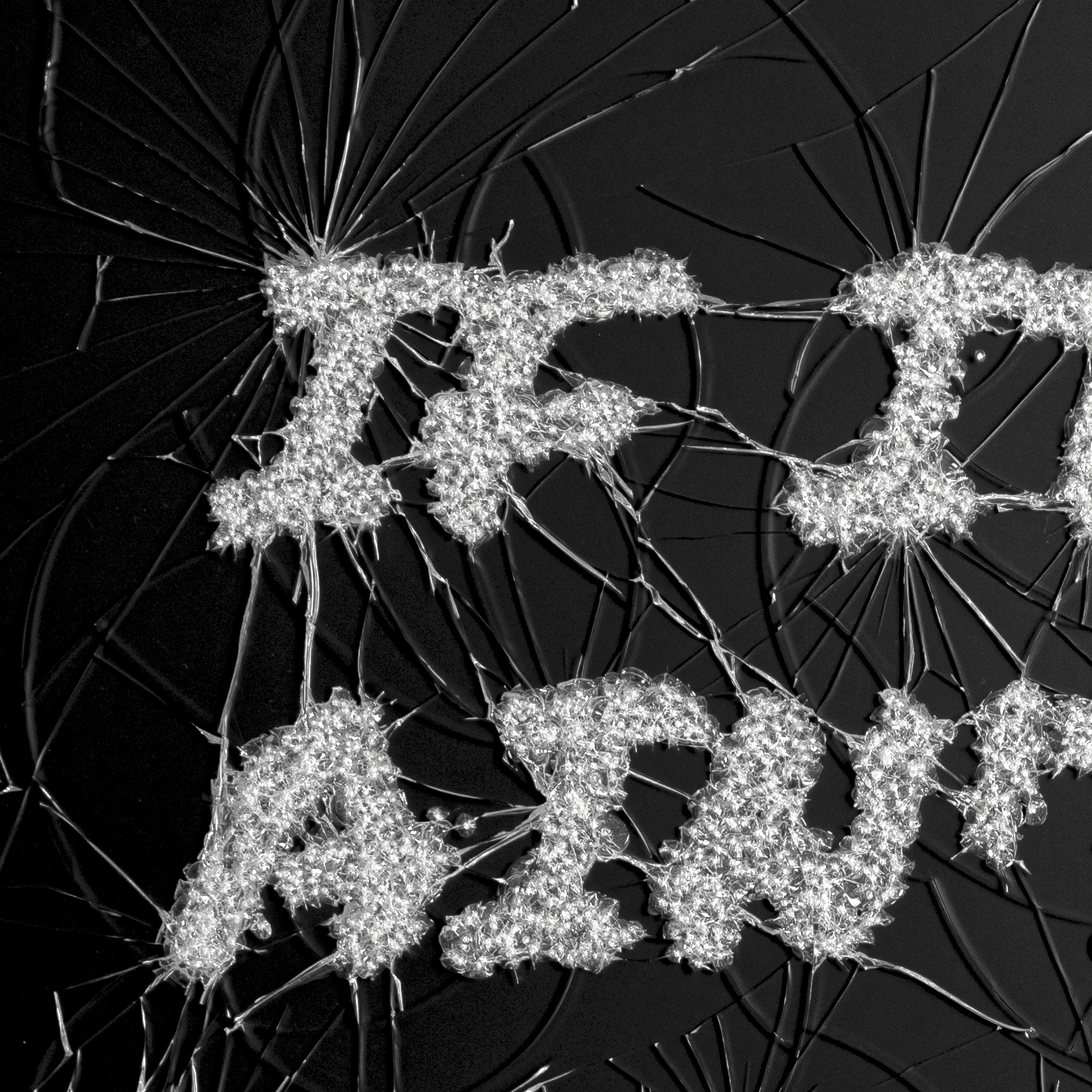 Close-up van een glaskunstwerk met scherpe lijnen van gebroken glas.