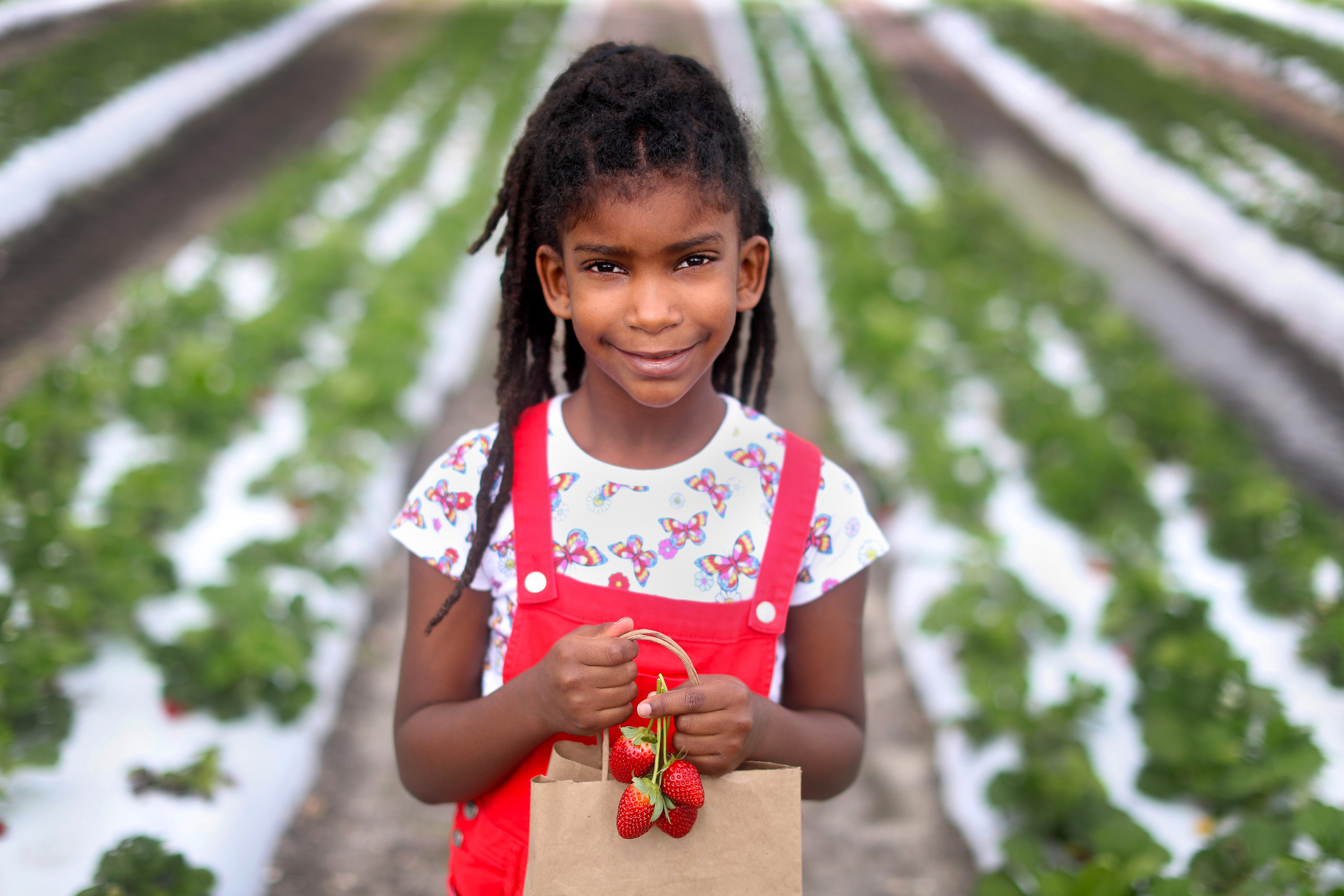 Henijah Marcano, 7,  shows her bag of freshly picked strawberries in, 2022 at Family Farms in Davie, Fl.