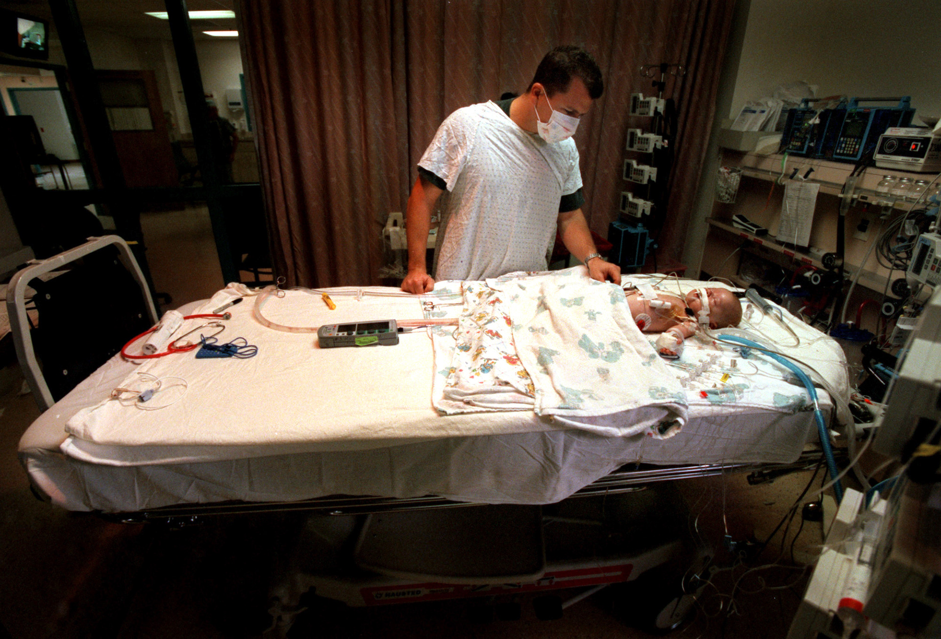 Chris Crawford looks over his baby son, Spencer, after undergoing a heart transplant in 2000 in Florida.  Spencer was born with hypo plastic left heart syndrome, a congenital defect that leaves an underdeveloped left ventricle unable to pump oxygenated blood to the body.