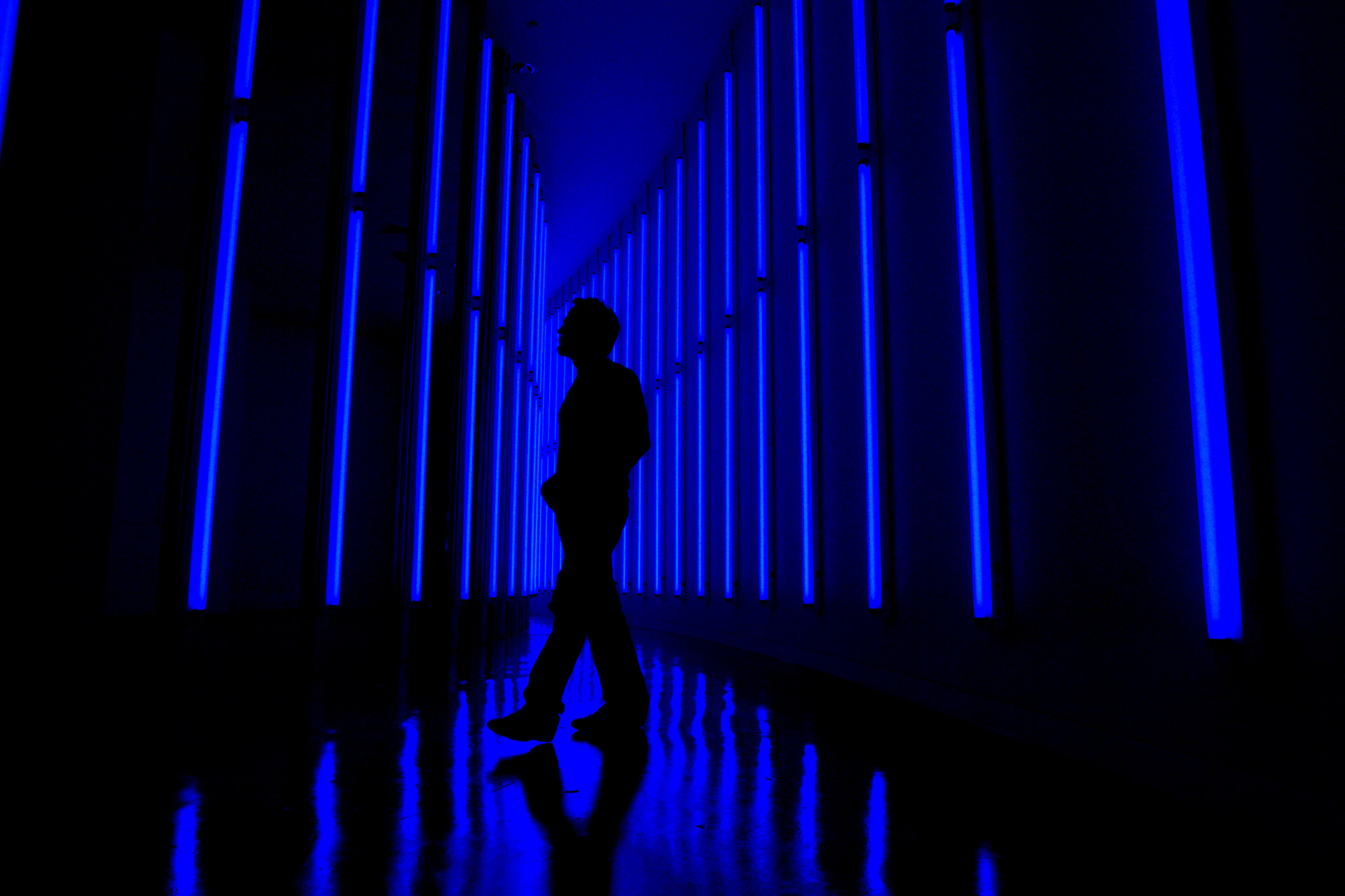 Artist Matthew Schreiber walks through his curved-light installation entitled "Pipeline (Tokyo)" which consists of 200 blue fluorescent lights mounted on vertical beams of galvanized steel inside the Fort Lauderdale Museum of Art in 2006.