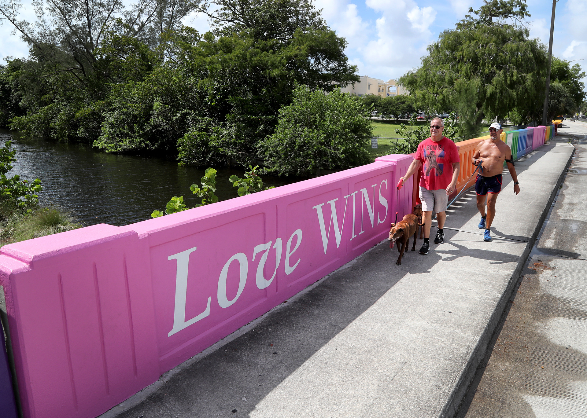 Dan Tyler and his husband Felipe Gonzalez walk their dogs over a rainbow colored bridge in Wilton Manors, Fl. in advance of the city's annual Stonewall Pride Parade in 2021.
