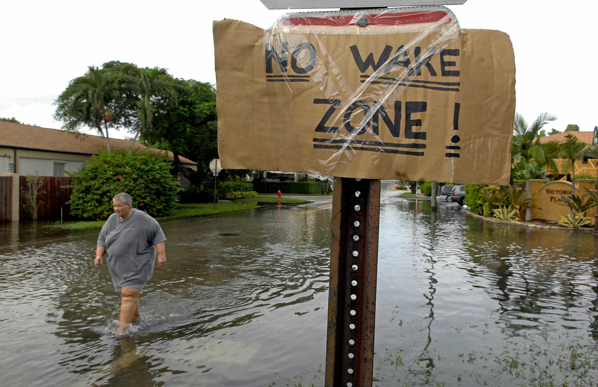 Cookie Williford treads through a flooded Fort Lauderdale neighborhood in 2011. "Please stop the wake, you're pushing water into people's homes," Williford pleaded as cars drove by. 