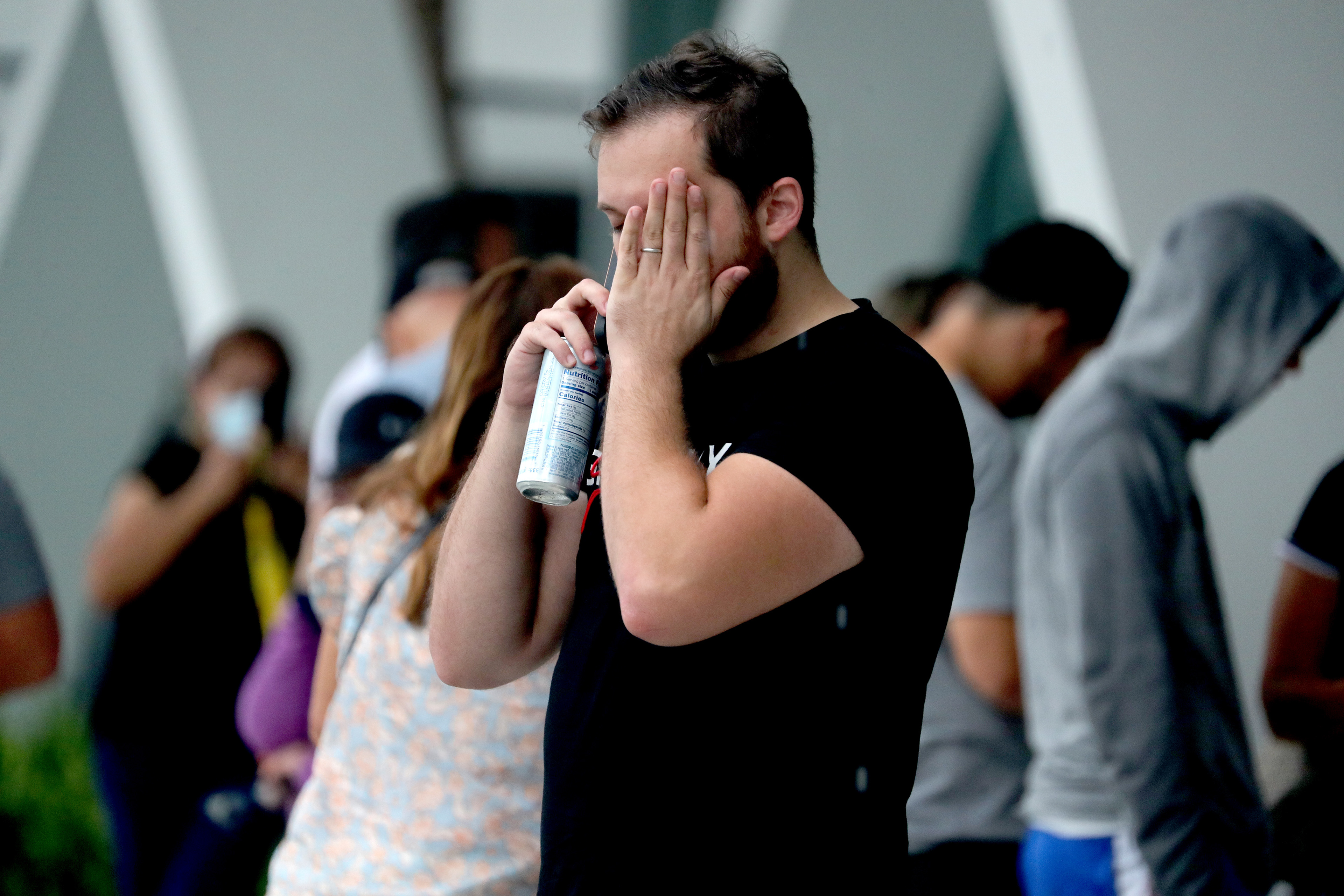 A man speaks on his cell phone at a makeshift family reunification center in Surfside, Fl. hours after the partial collapse of the Champlain Towers South beachfront condo that caused the deaths of 98 people.