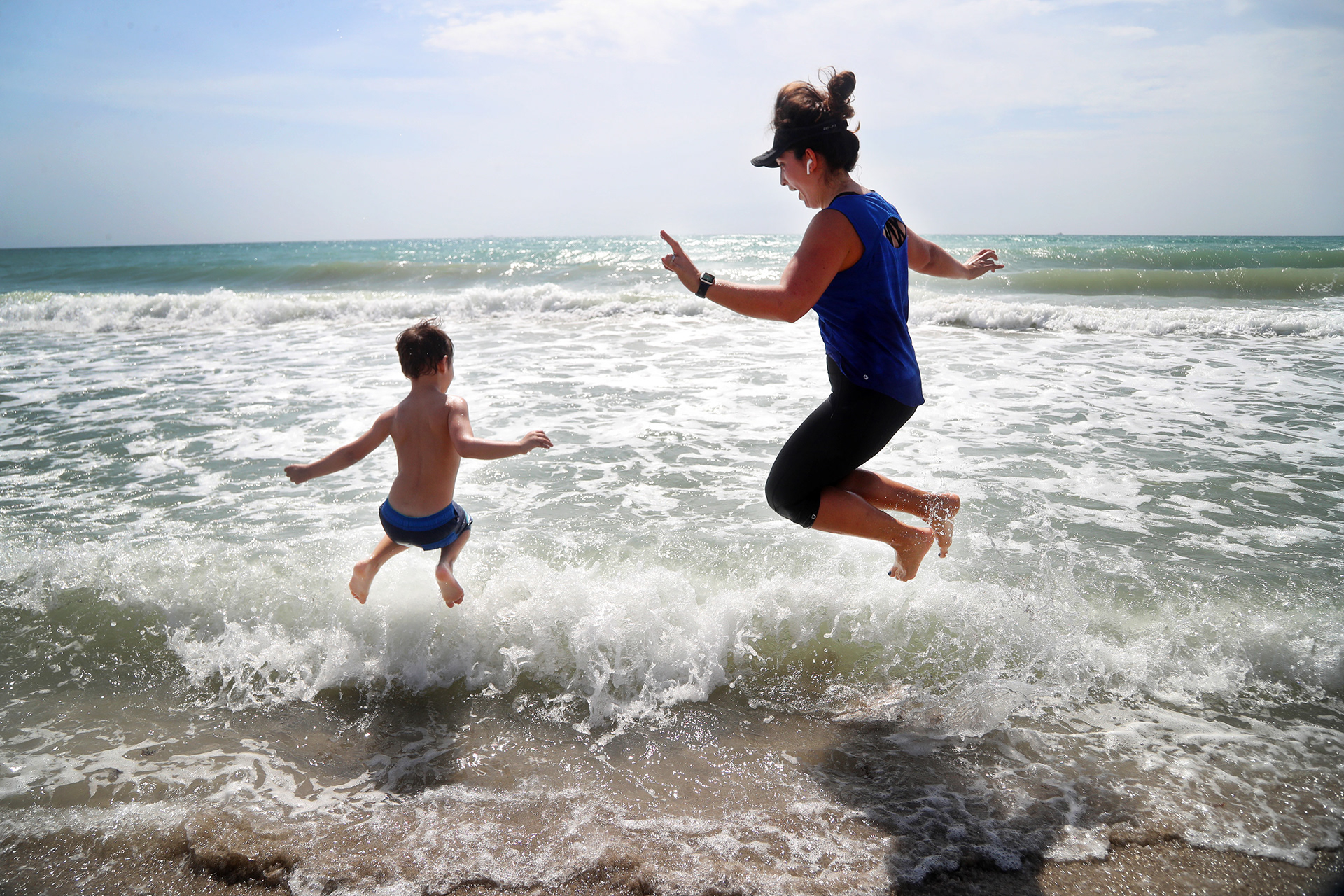 Dylan Walter, 4, and his mother, Duygu, jump into the ocean in Hollywood, Fl. as they celebrate Broward County's reopening of beaches that were temporarily closed at the beginning of the COVID-19 pandemic in 2020.  