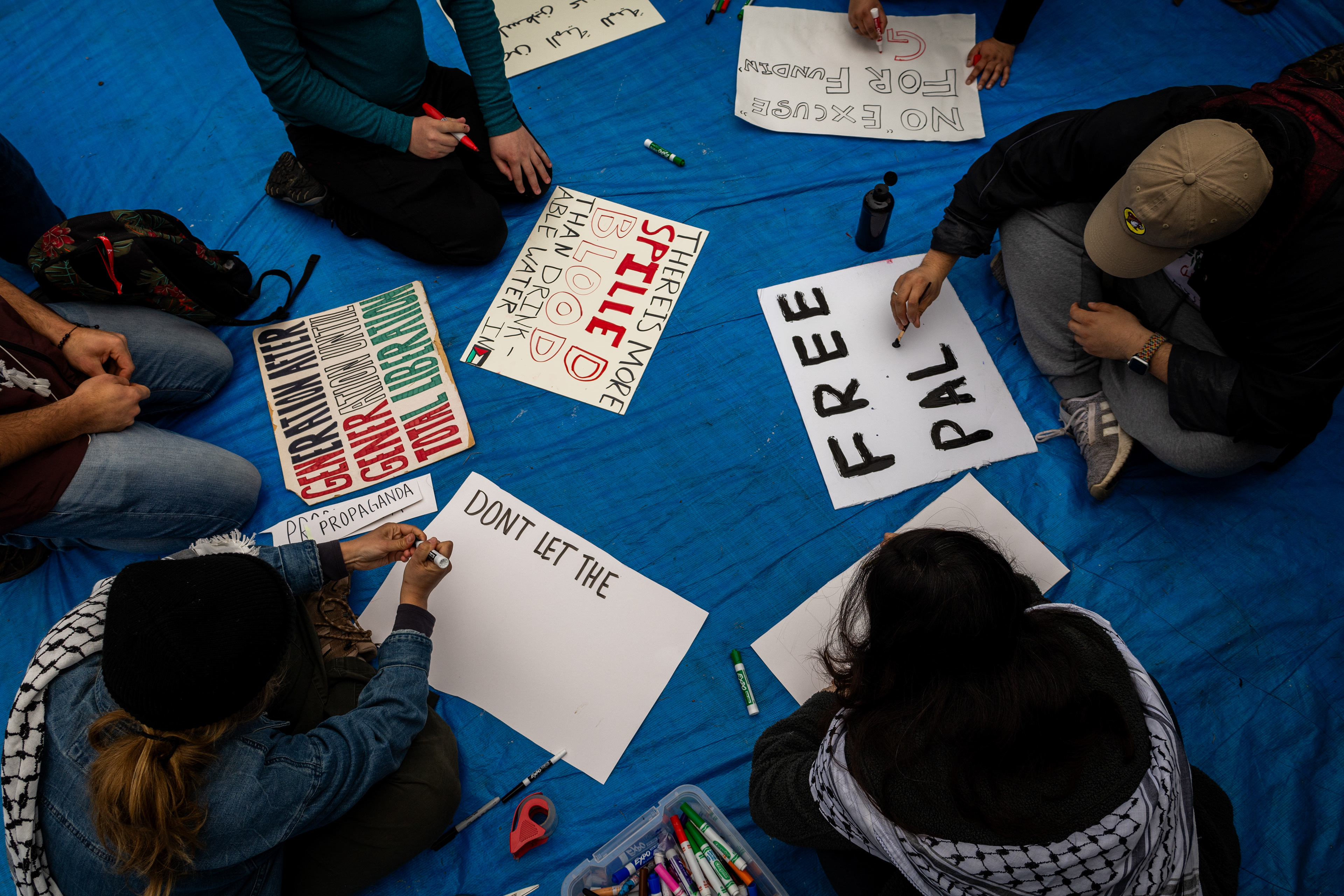 Cambridge, Mass. — Protesters make signs inside M.I.T.'s encampment protesting M.I.T.'s connections to the Israeli government.