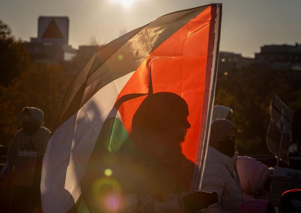 Boston — A protester marches over the Harvard Bridge towards Cambridge, Mass. at sunset.