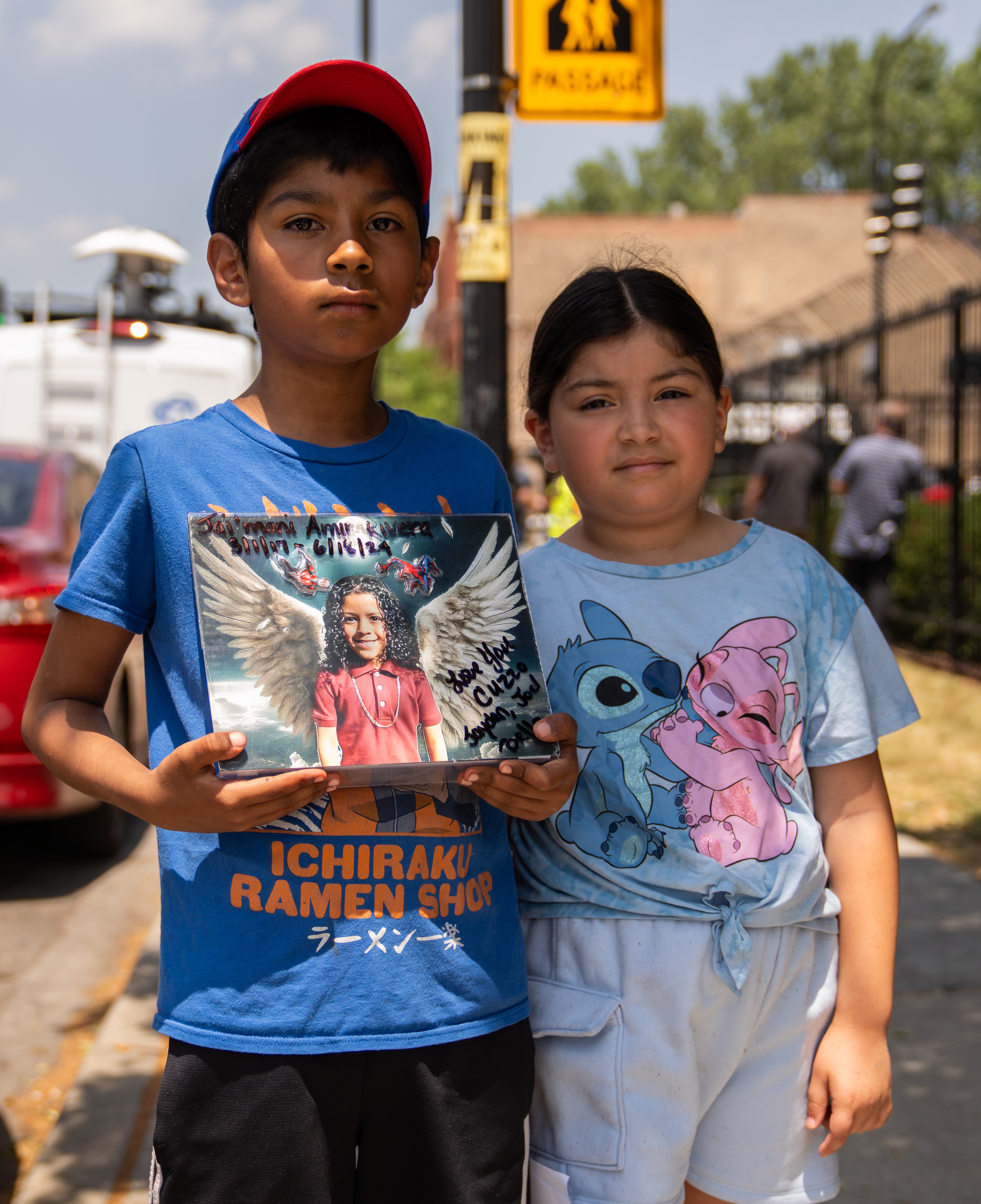 Chicago — Joel Rivera, 10, stands with Isabella Rivera, 10, and holds a photo of his cousin Jai'mani Amir Rivera,  who was shot and killed by a stray bullet in front of his apartment building on June 18, 2024.