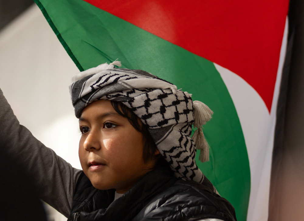 A young protester waves a Palestinian flag with his head wrapped in a Keffiyeh during a protest in Washington D.C. in early November, 2023. 