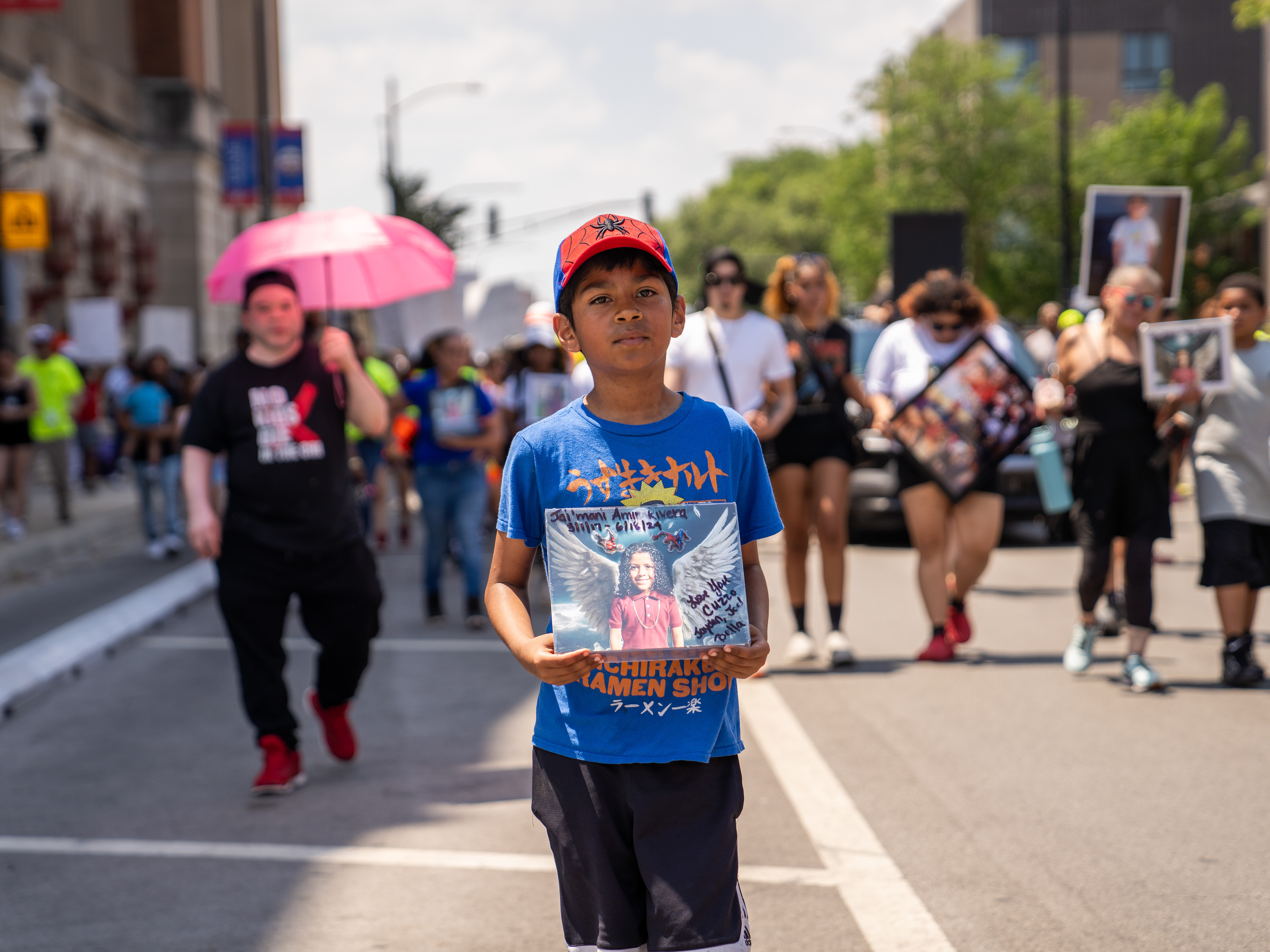 10-year-old Joel Rivera holds a photo of his cousin, Jai'mani Amir Rivera, 7, who was killed when a stray bullet struck him in the chest in Chicago, Ill. on June 18, 2024. 