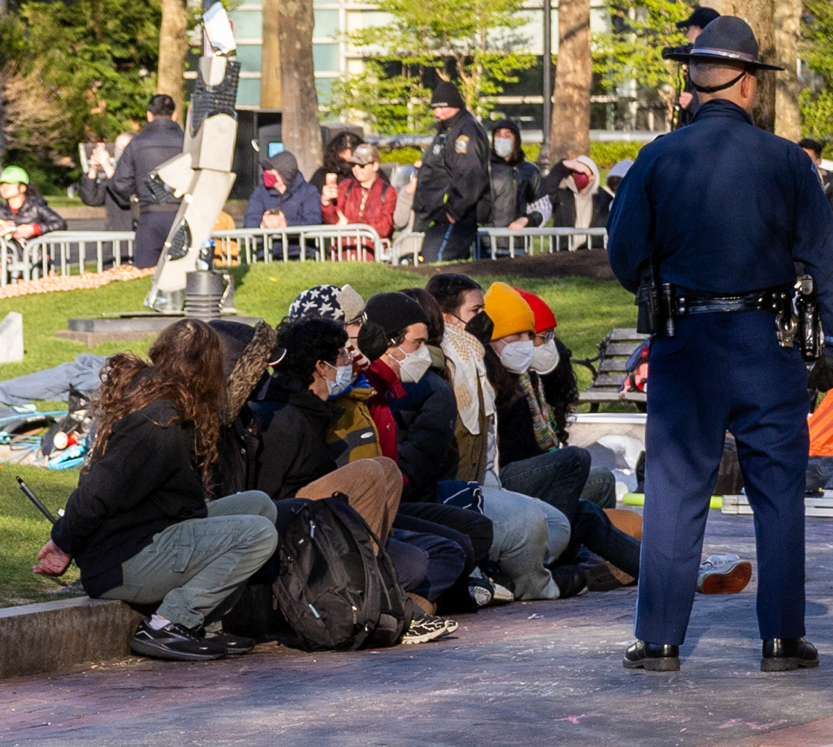 Boston — Protesters sit on the curb awaiting arrest at Northeastern University in Boston.