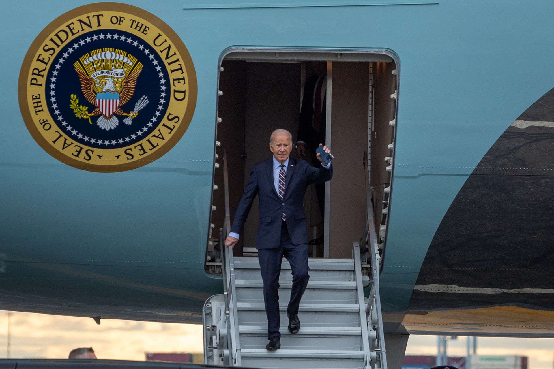 Boston — President Joe Biden waves as he steps off Air Force One after arriving at Boston Logan International Airport, Dec. 5, 2023. 