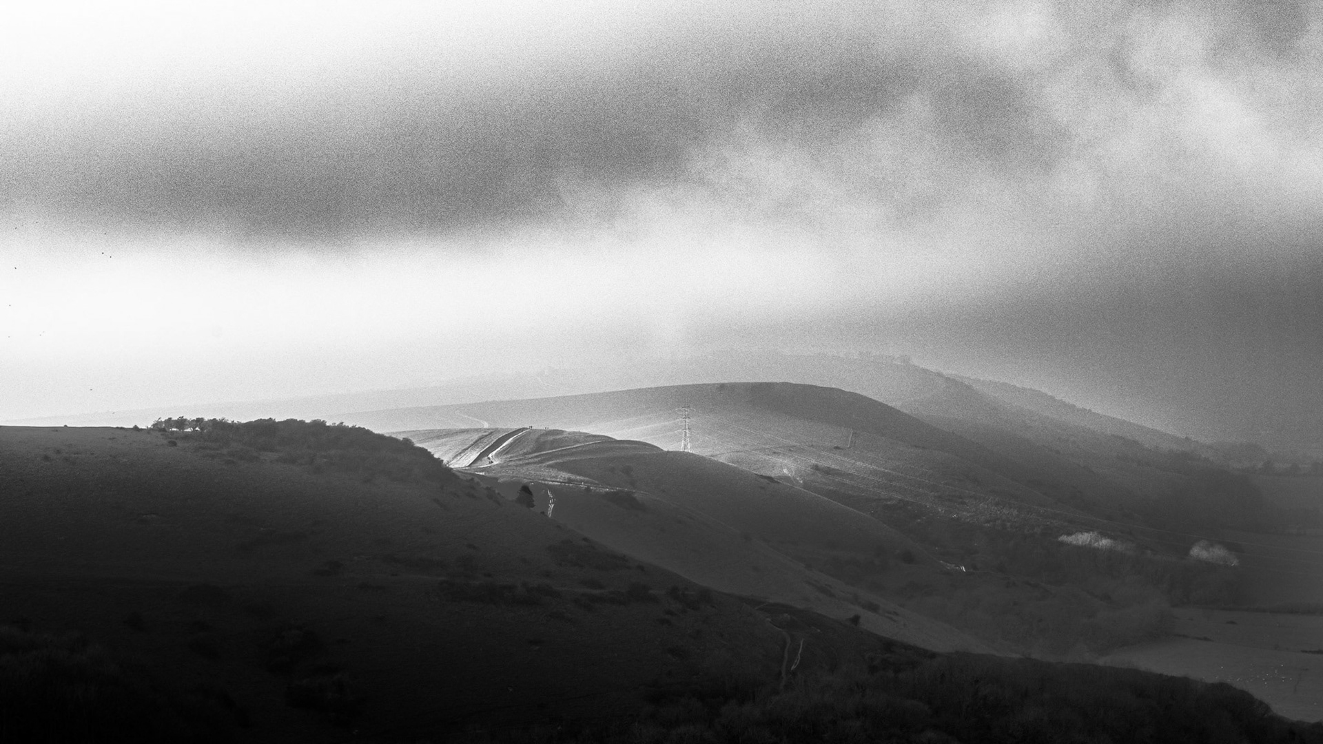 The sun briefly breaks through fog. Looking West from Devils Dyke