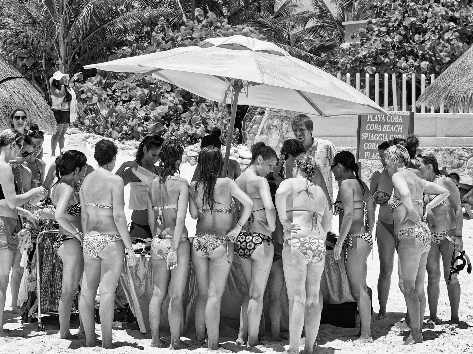 A beach seller attracts quite a crowd on this Mexican beach.