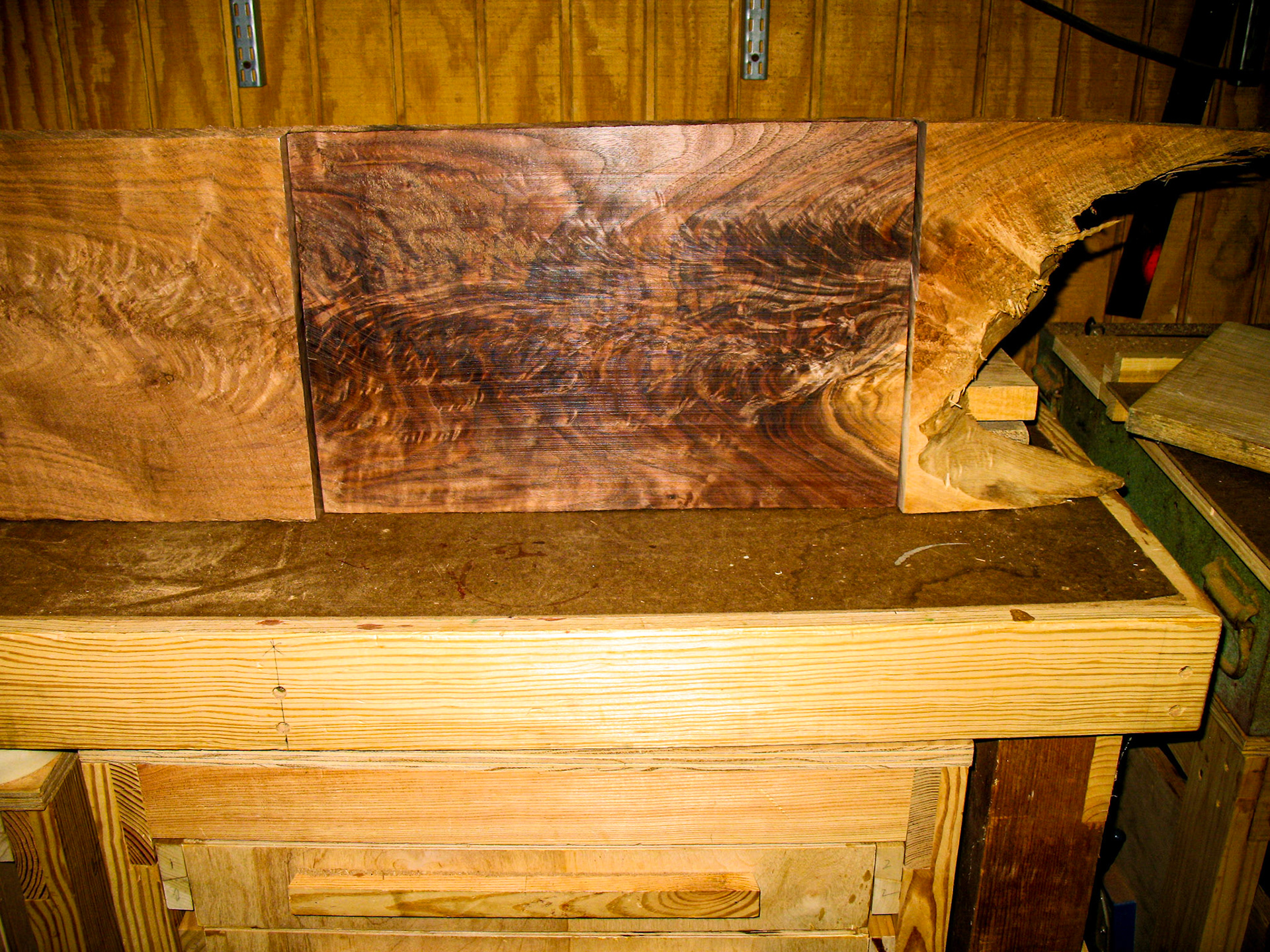 The figured walnut board surrounded by the rough board it was cut from.