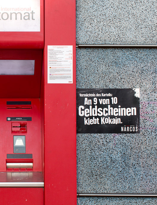Ein kontextueller Aufkleber, der mit beeindruckenden Fakten für die Netflix Serie Narcos wirbt. Er ist in direkt neben einem Geldautomaten platziert. Auf dem Aufkleber steht: Vermächtnis des Kartells: An 9 von 10 Geldscheinen klebt Kokain. Narcos. Ein Netflix Original.