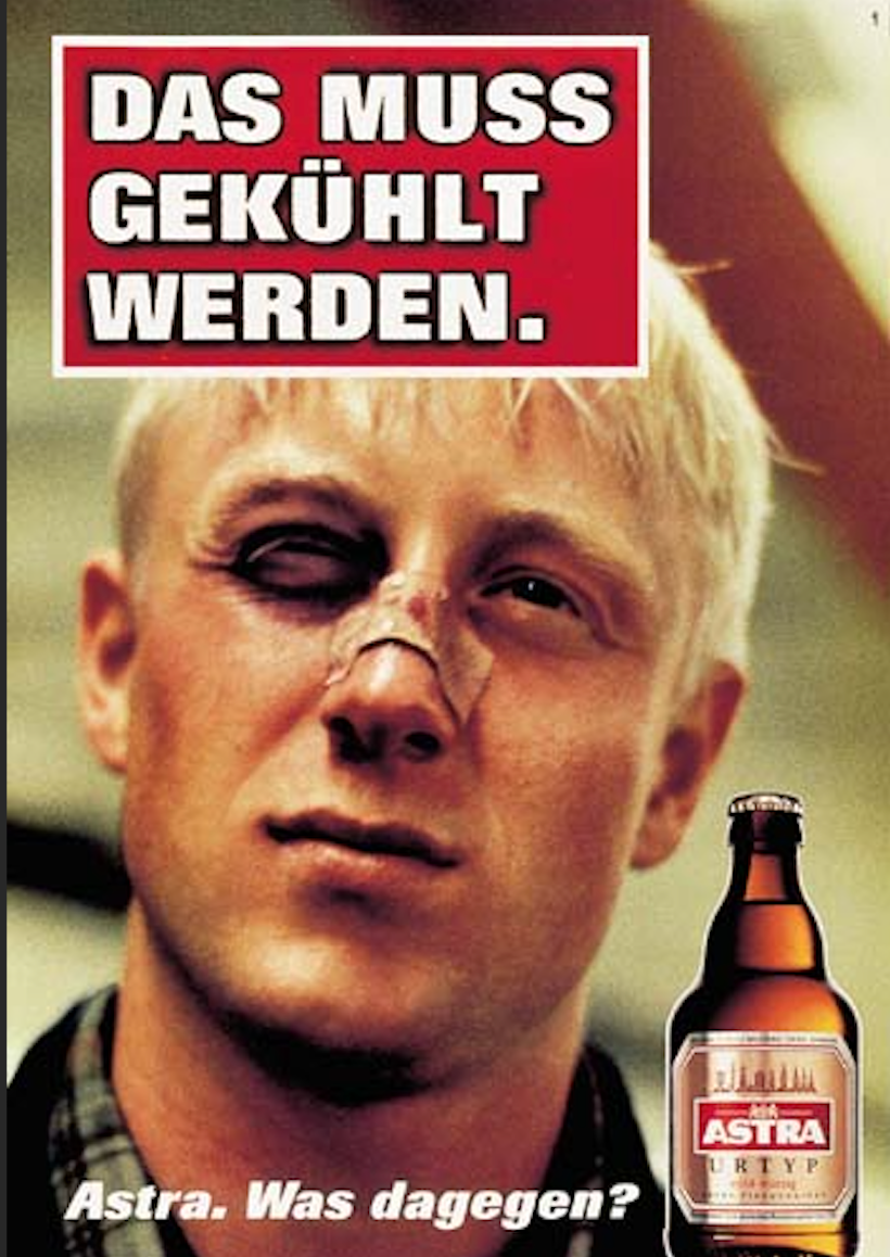 Ein Plakat für die Biermarke Astra. Wir sehen einen jungen Typen mit blauem Auge und Plaster auf der Nase. Dazu steht groß: Das muss gekühlt werden. Unten neben der Bierflasche steht: Astra. Was dagegen?