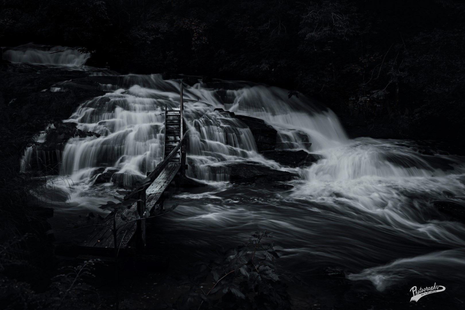 Nesten svarthvitt bilde av Sagelva, ved Strømmen. 