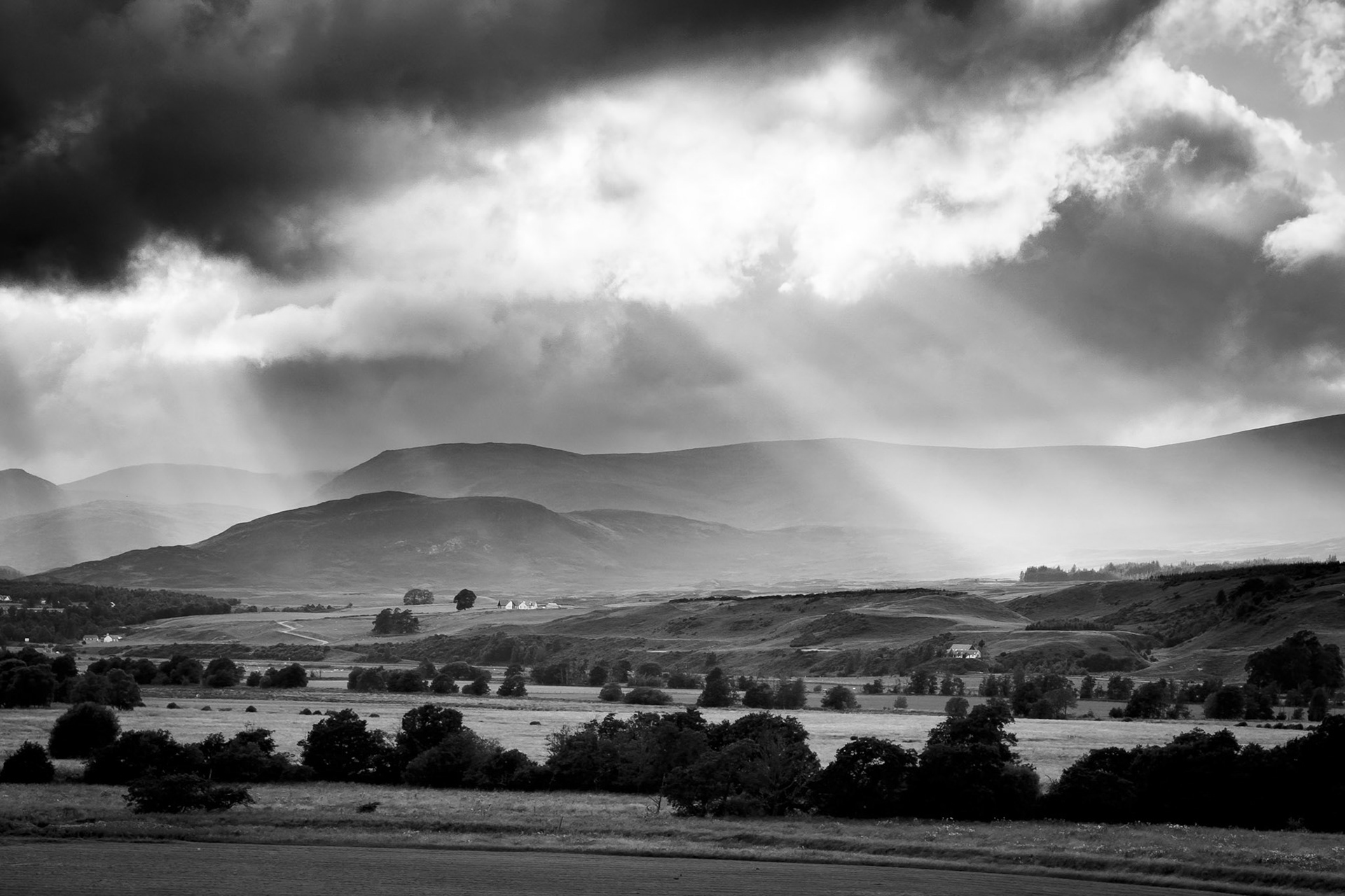 Sunbeams shine through the stormy skies of the Cairngorms, Scotland