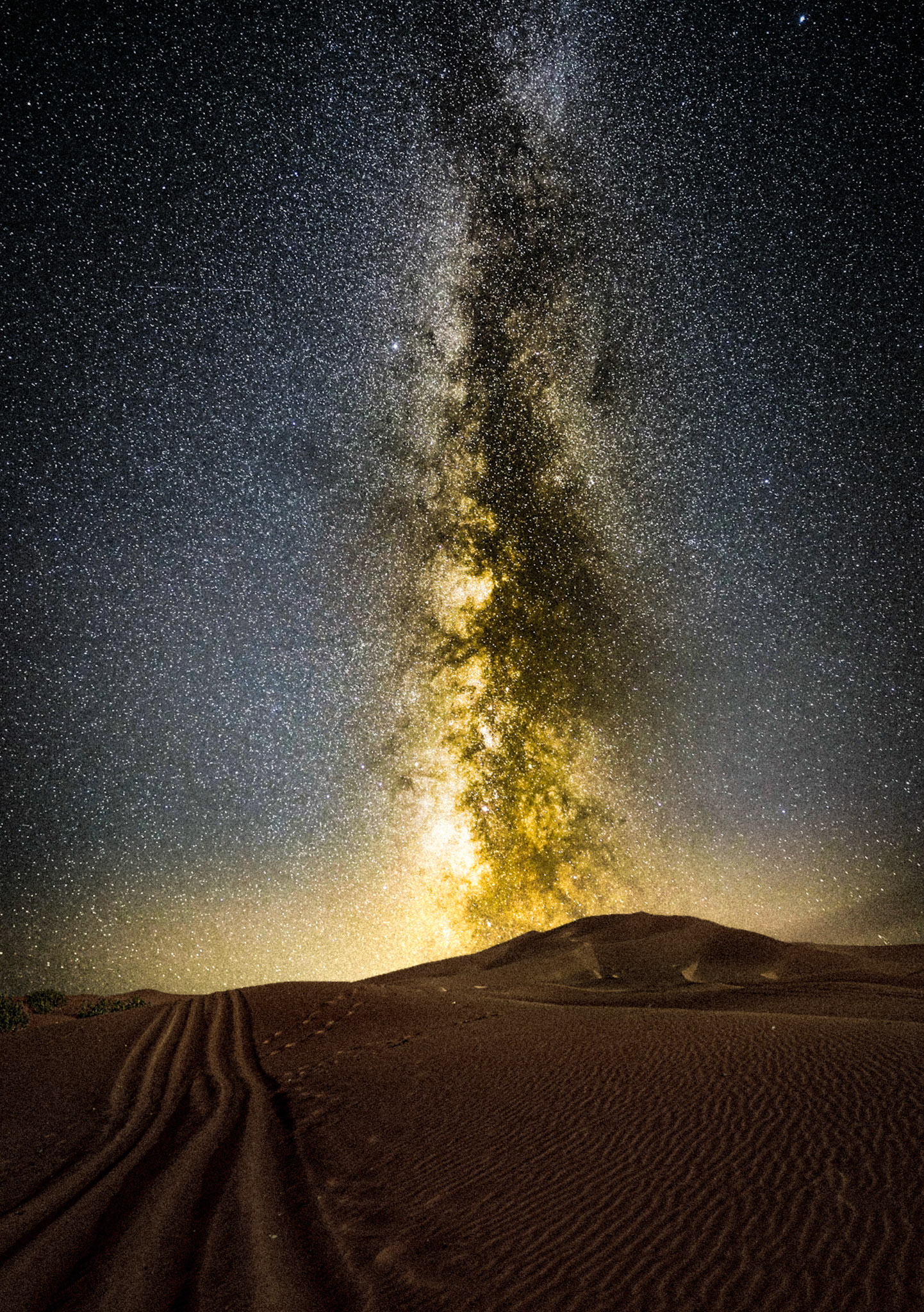 The warm colours of the milky way are visible from the darkest skies I've seen in the sahara desert in Morocco, with sand dunes in the foreground.