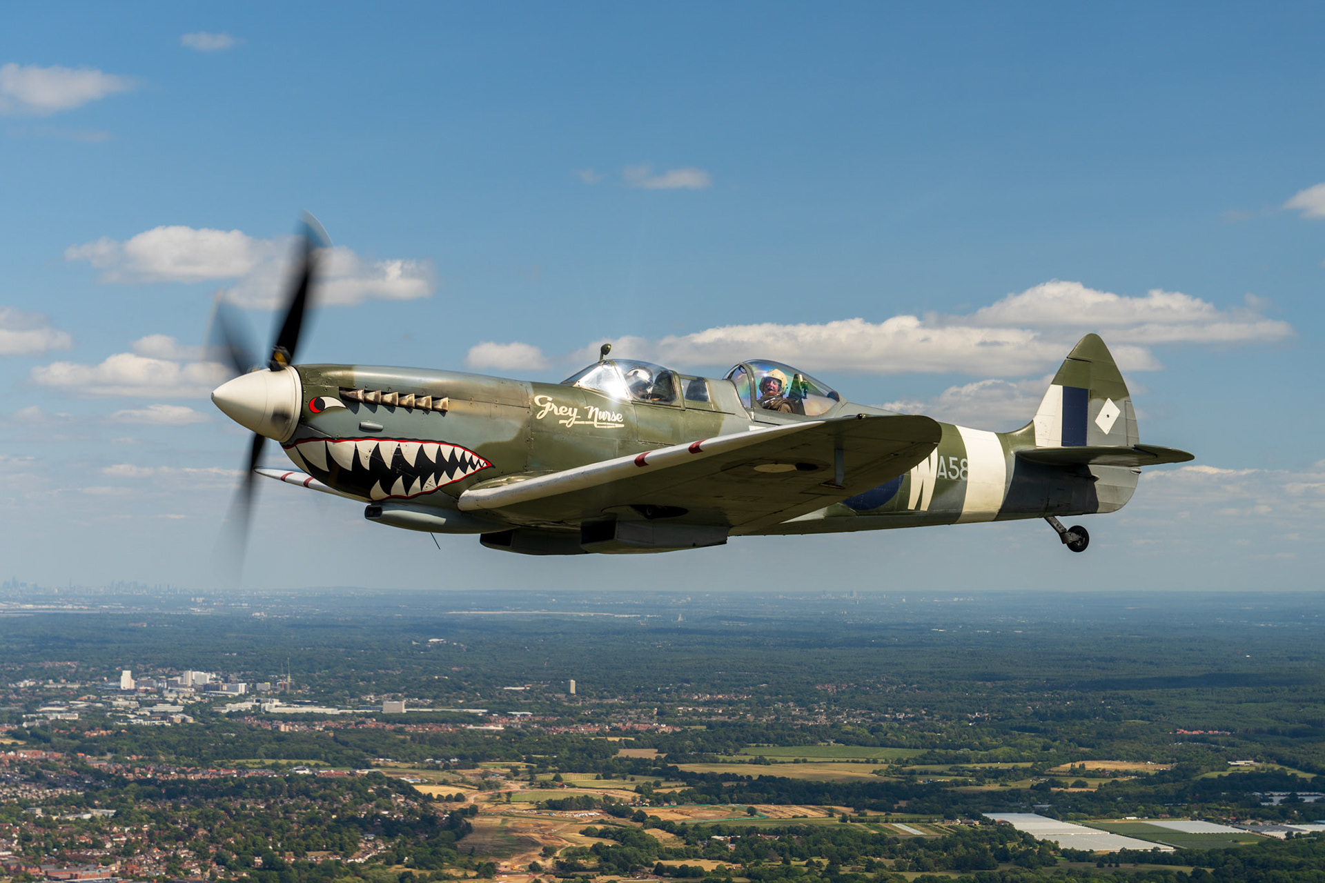 Spitfire in flight over british countryside.