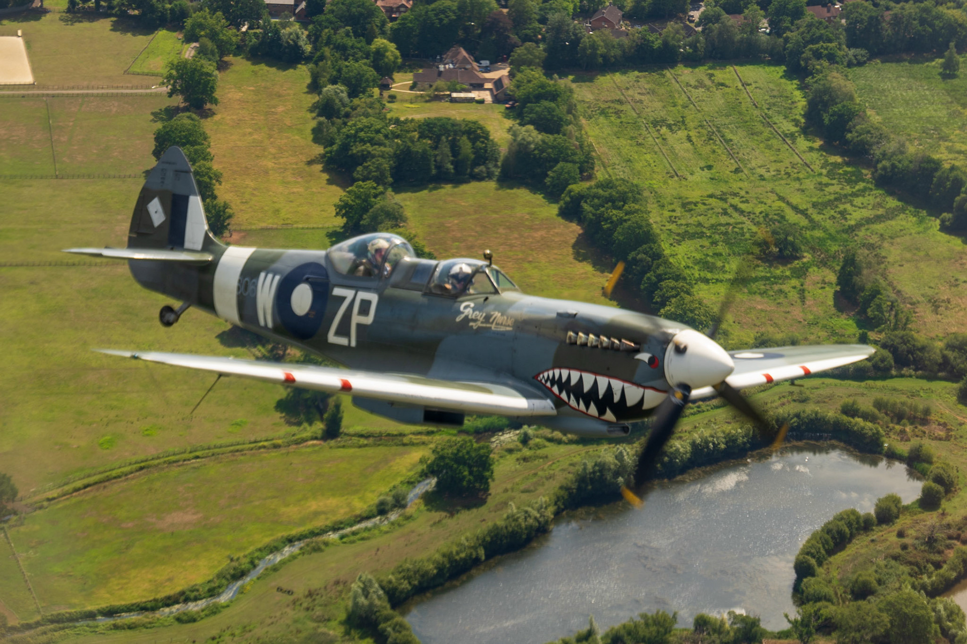 Spitfire in flight over british countryside.