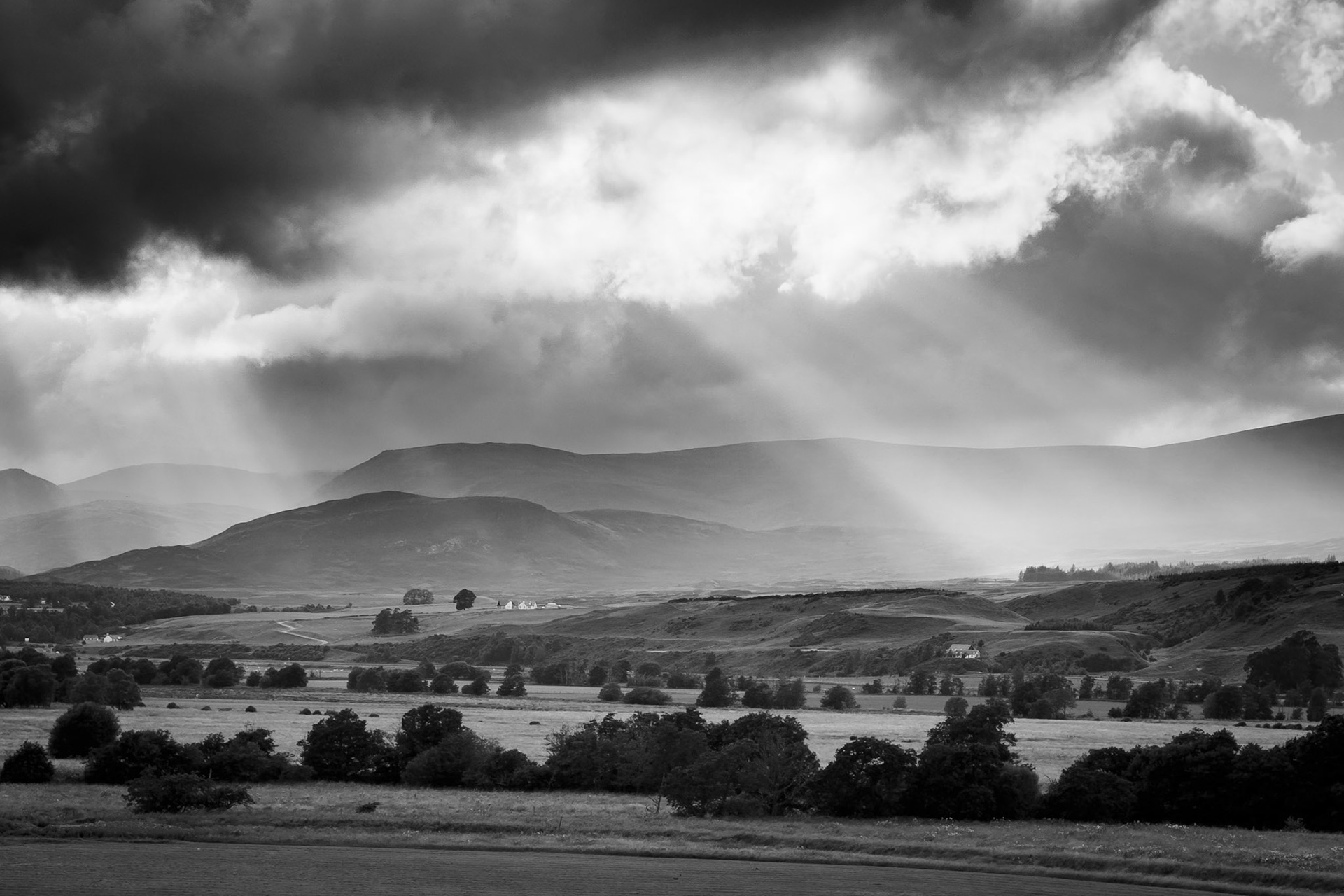 Sunbeams shine through the stormy skies of the Cairngorms, Scotland