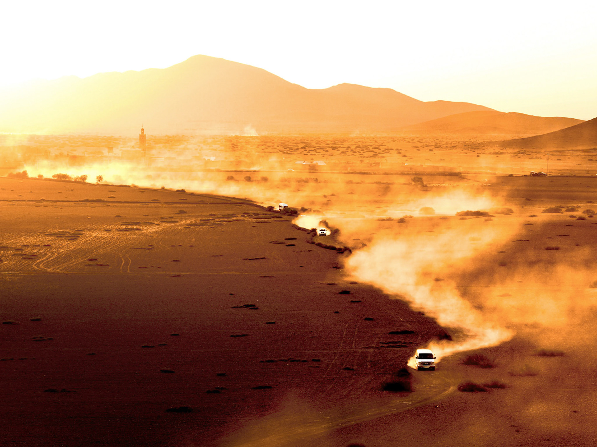 Cars driving through the desert near Marrakech, creating a cinematic moment, Morocco
