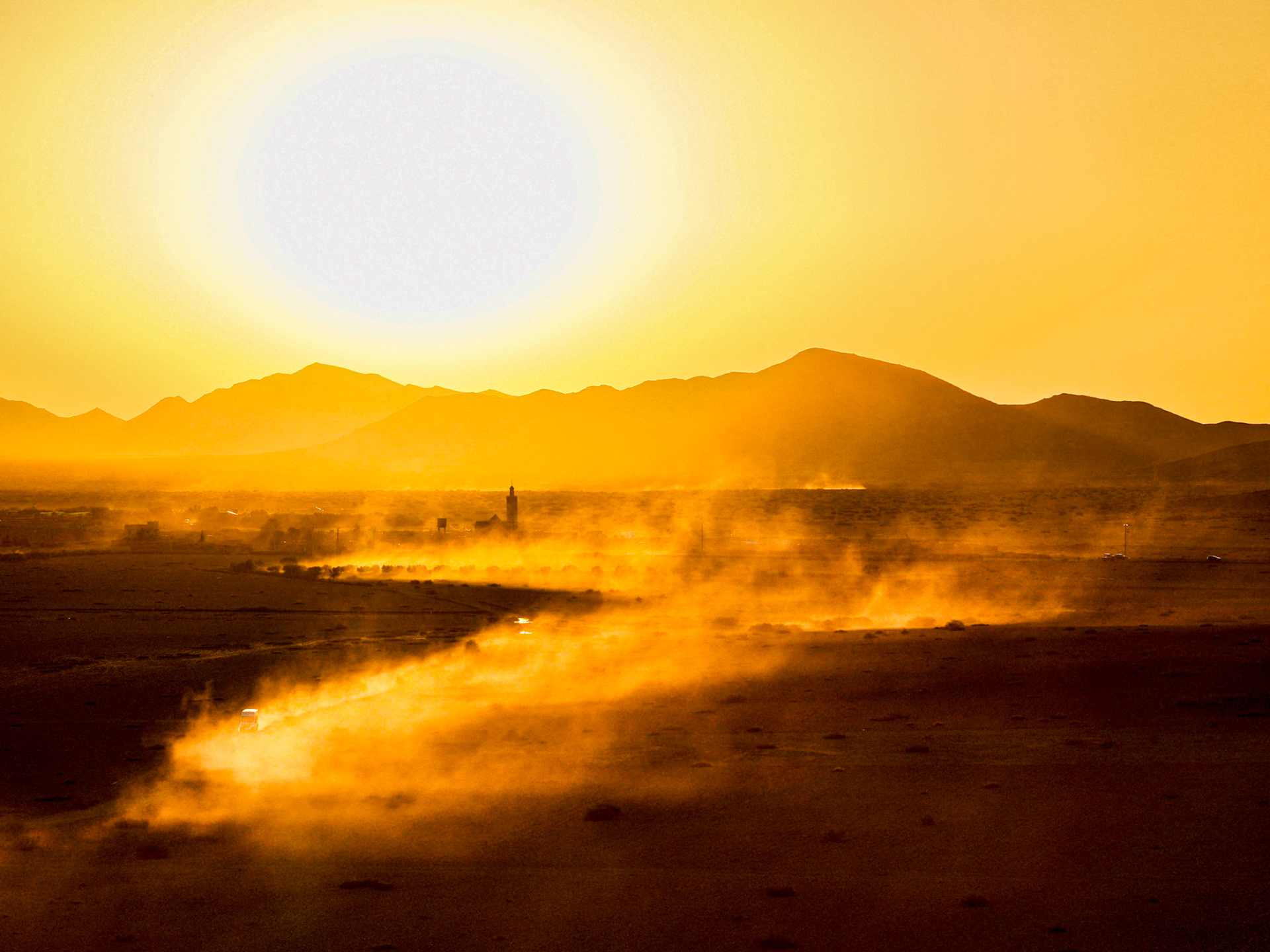Cars driving through the desert near Marrakech, creating a cinematic moment, Morocco