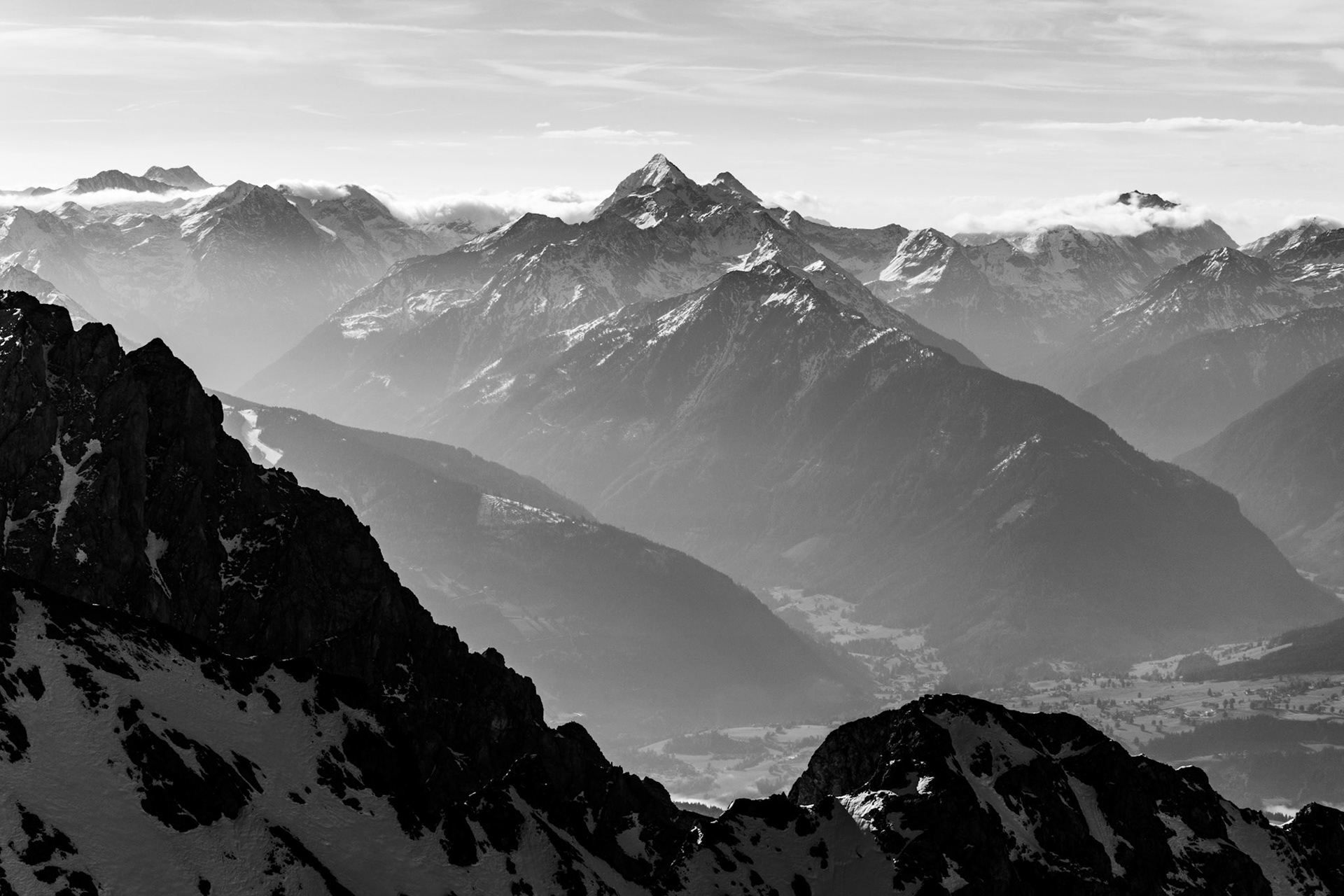 Layers of distant mountains are visible in this Austrian alpine scene, down to the valley floor. Black and White