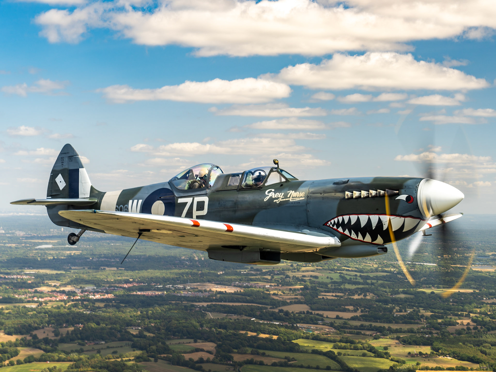 Spitfire in flight over british countryside.