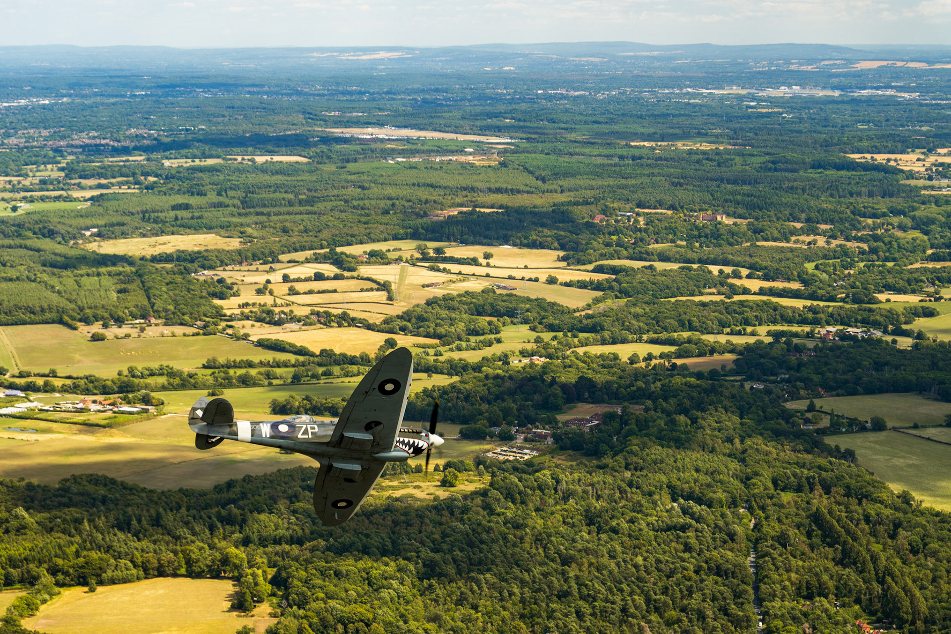 Spitfire in flight over british countryside.