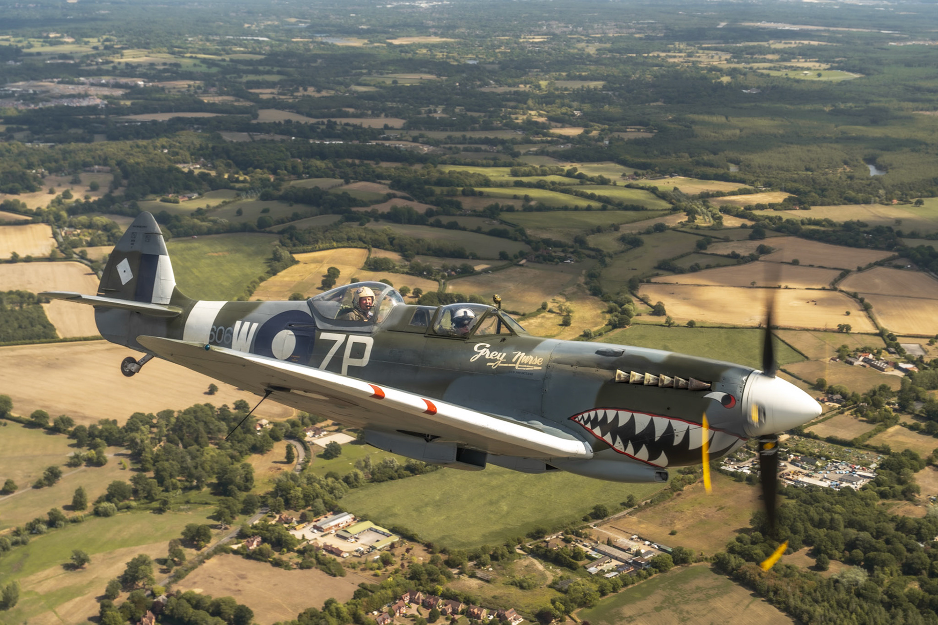 Spitfire in flight over british countryside.