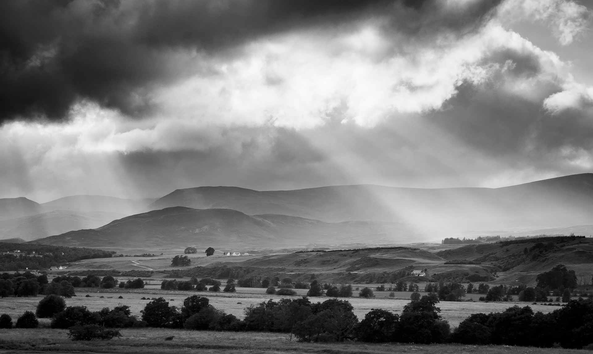 Sunbeams shine through the stormy skies of the Cairngorms, Scotland