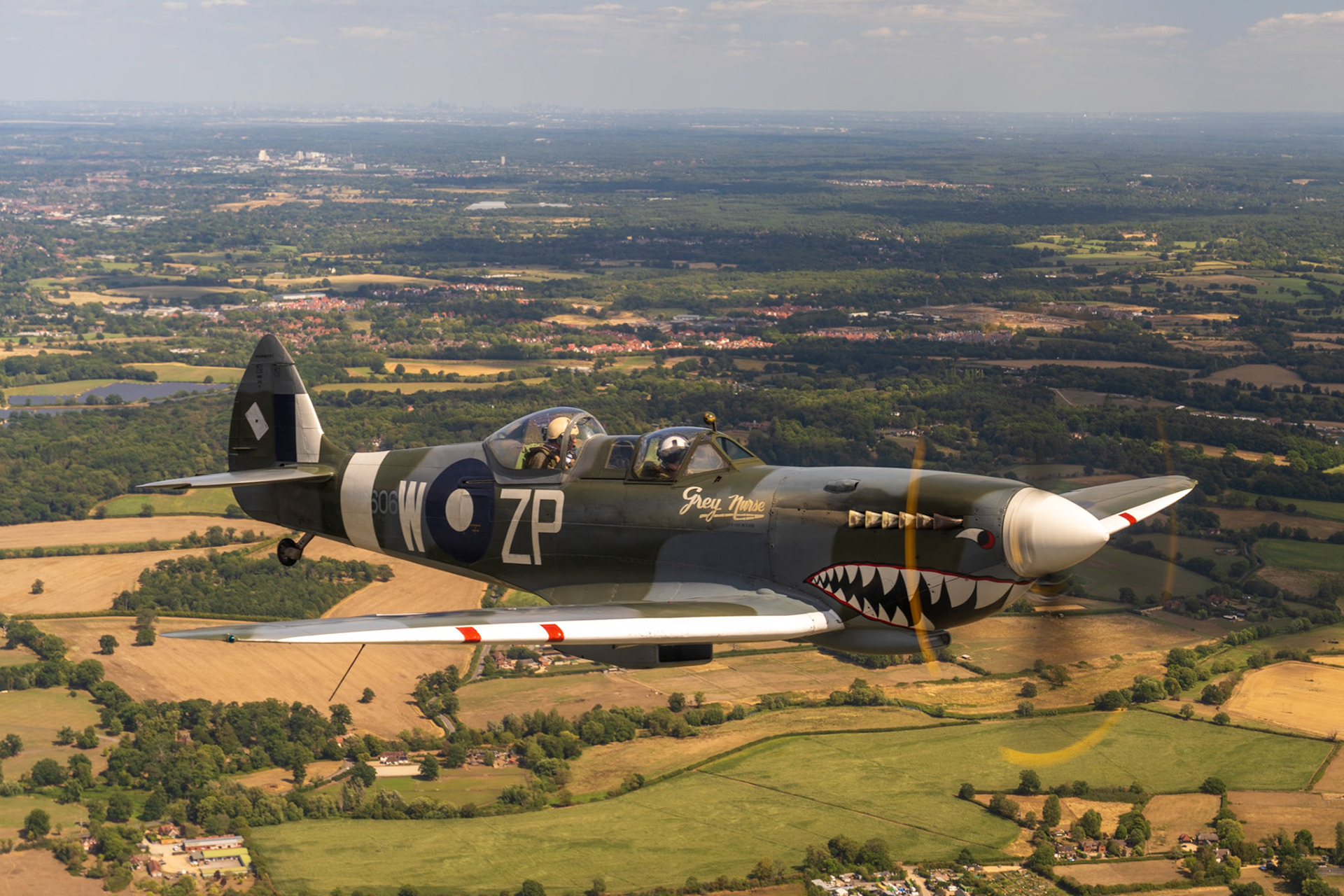 Spitfire in flight over british countryside.