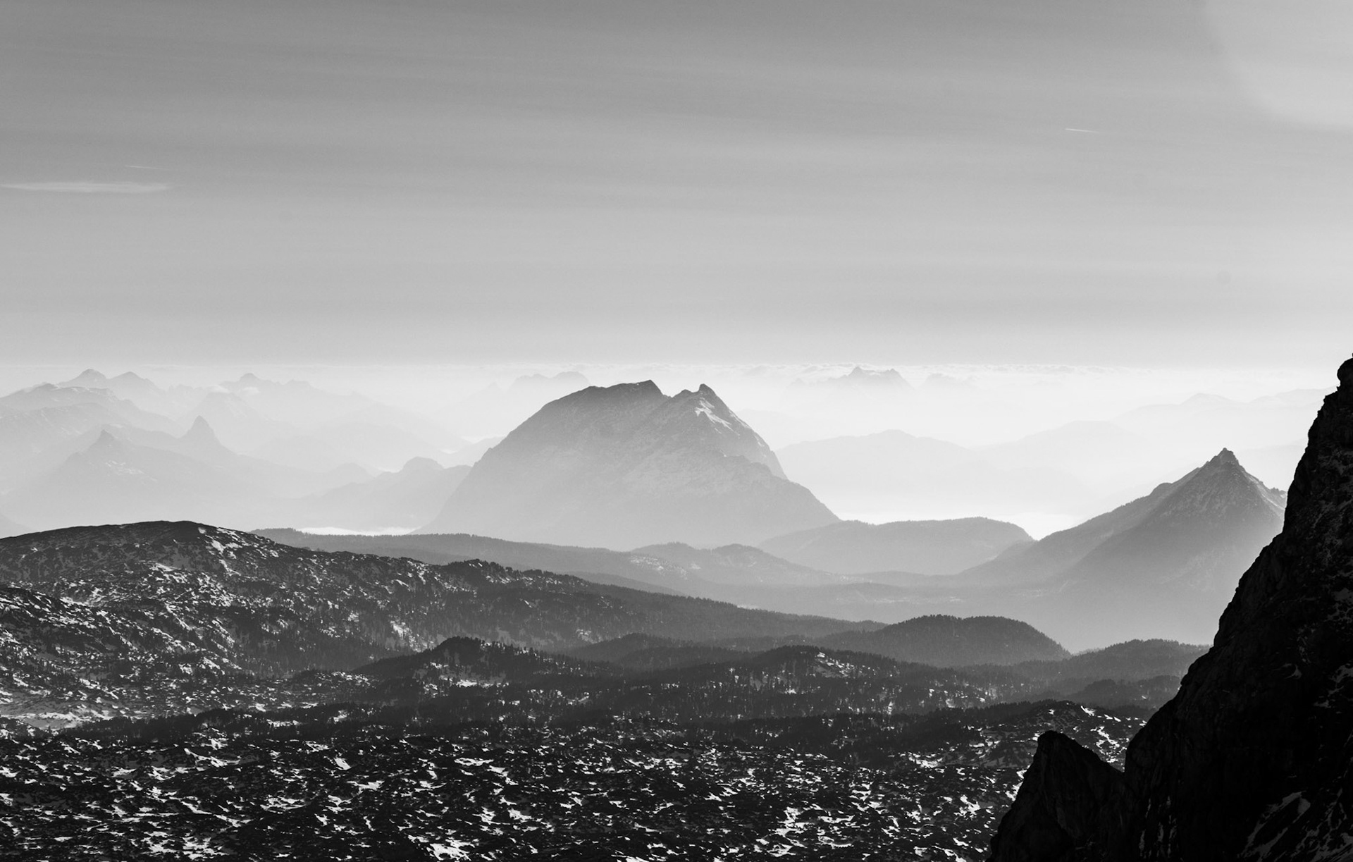 Layers of distant mountains visible in this Austrian alpine scene. Black and White