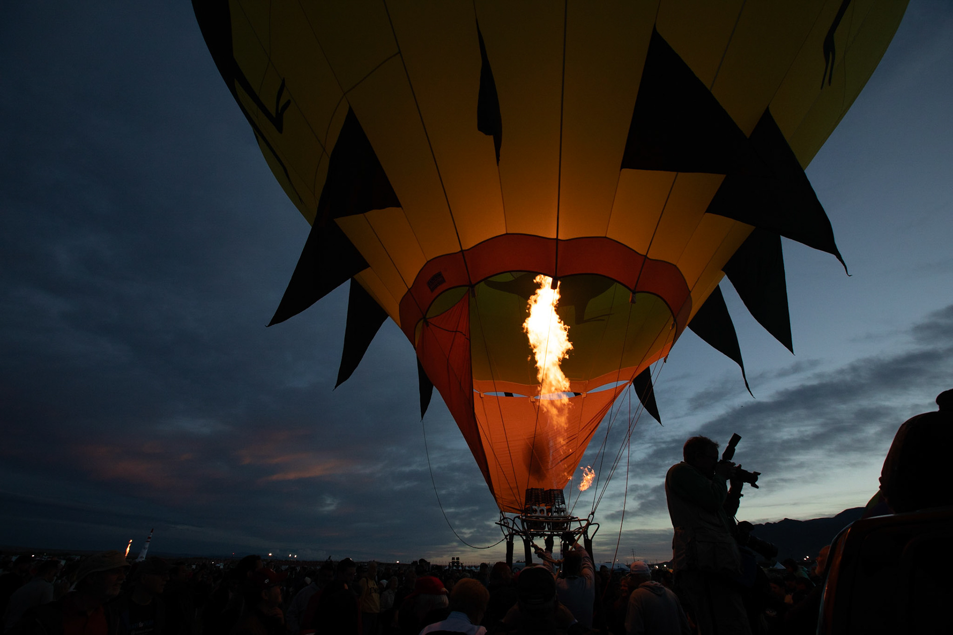 Balloonist prepares for takeoff while photographer records the scene.