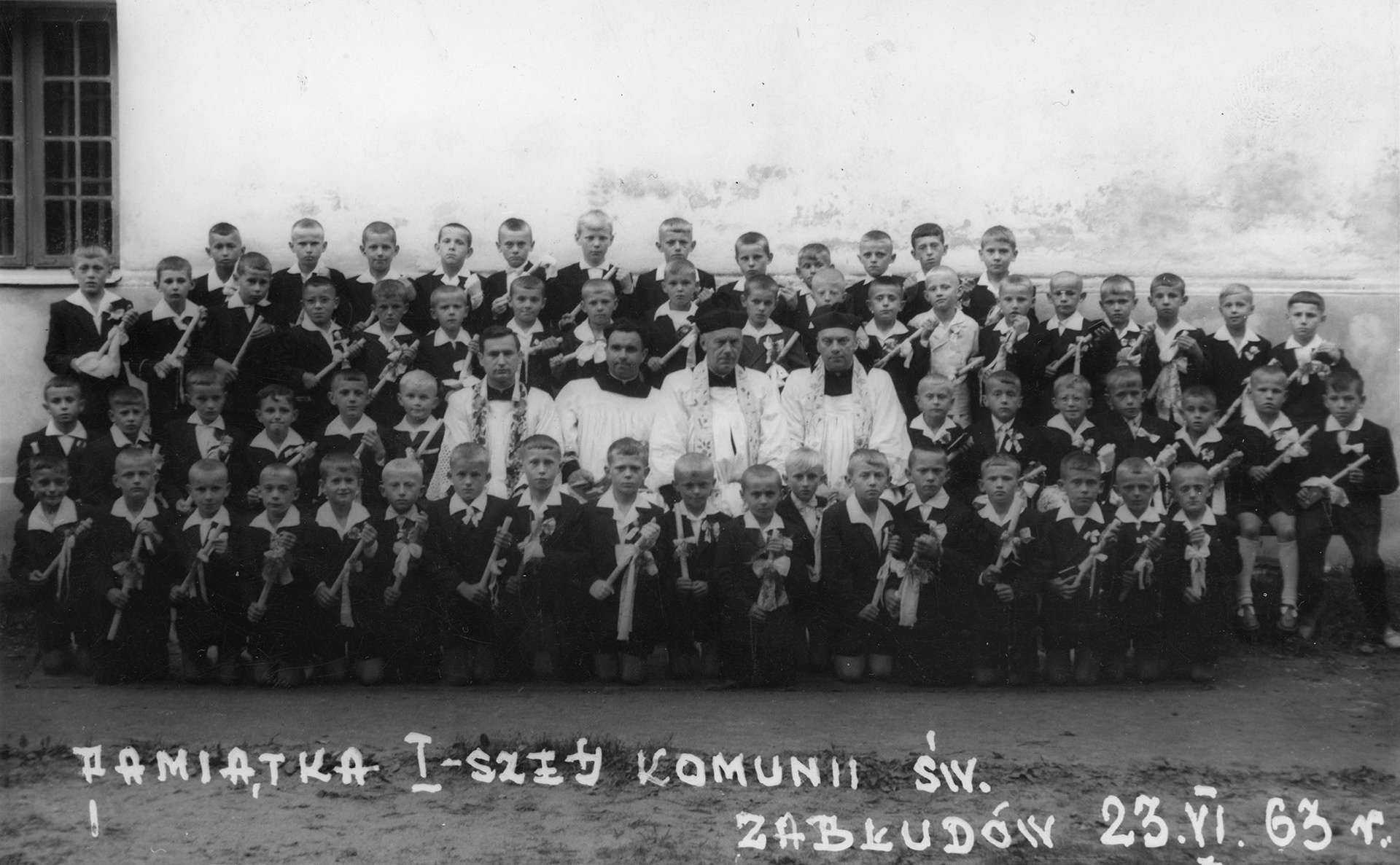 1963.06.23 | Pamiątka Pierwszej Komunii Świętej - księża od lewej: ks. Henryk Abramowicz, ks. Czesław Czerwiński, ks. proboszcz Jan Skarzyński, ks. Antoni Kruk - wśród dzieci 1. od lewej u dołu Tadeusz Samsonowicz, w drugim rzędzie od dołu 6. Tadeusz Stelmach | z arch. Marcina Ciuchnieckiego