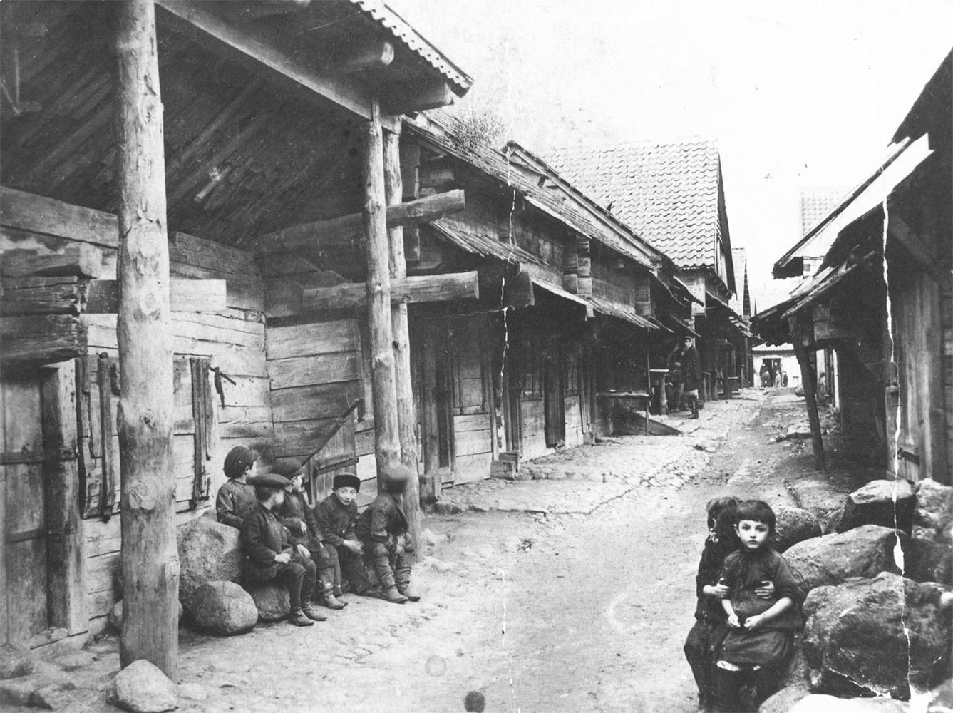 1916 | Sztetl - małe skupisko miejskie zachowujące tradycyjną obyczajowość żydowską - dzieci pozujące na tle drewnianej architektury Zabłudowa | z arch. YIVO Institute for Jewish Research (New York, USA)